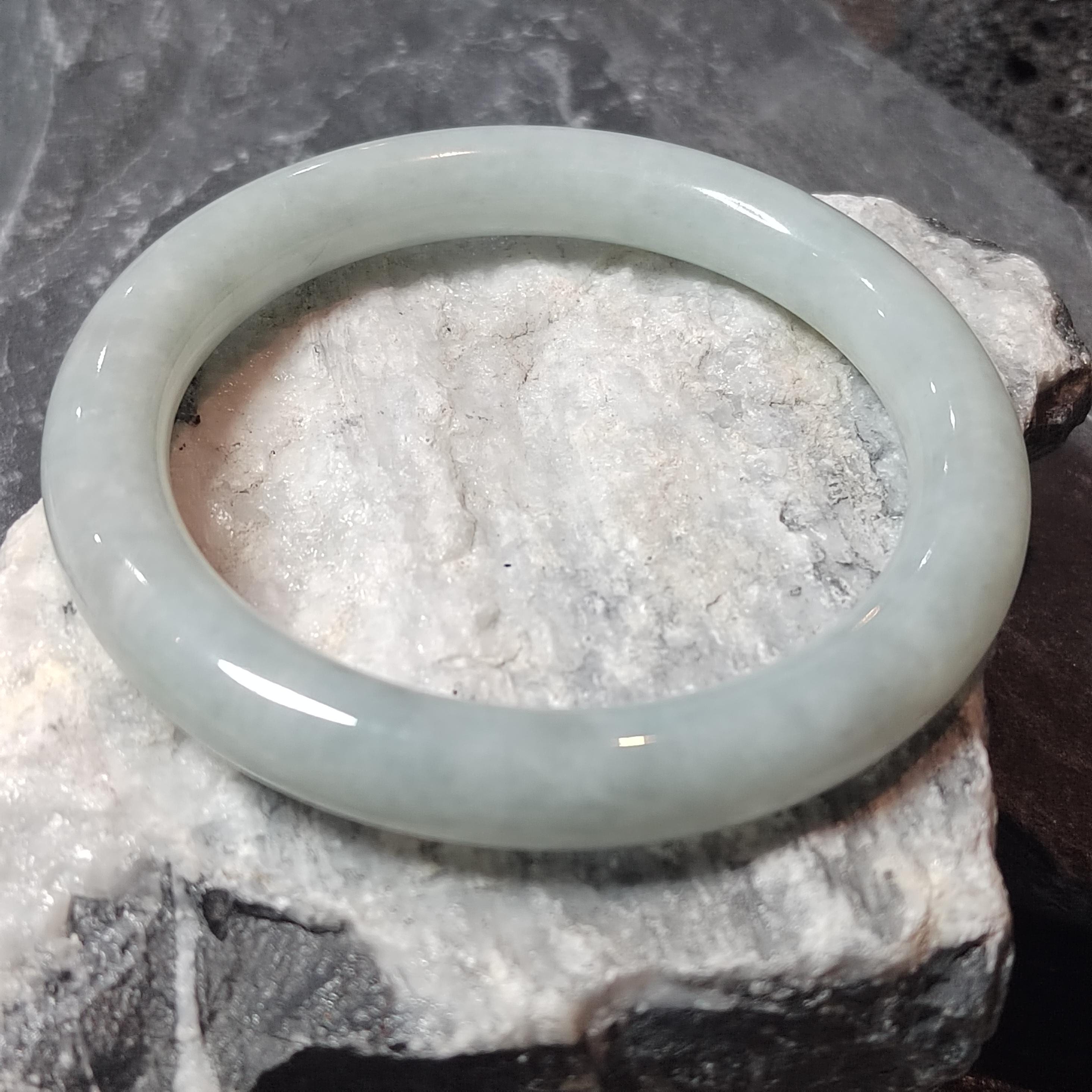 Green jade bracelet on a textured stone surface