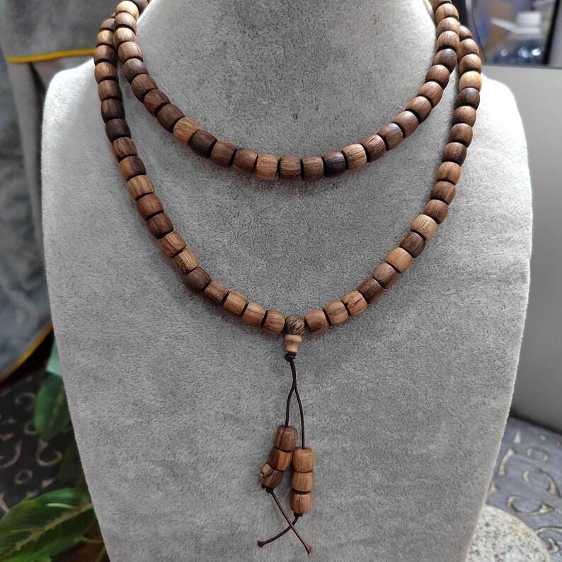 Wooden beaded necklace on a gray mannequin bust