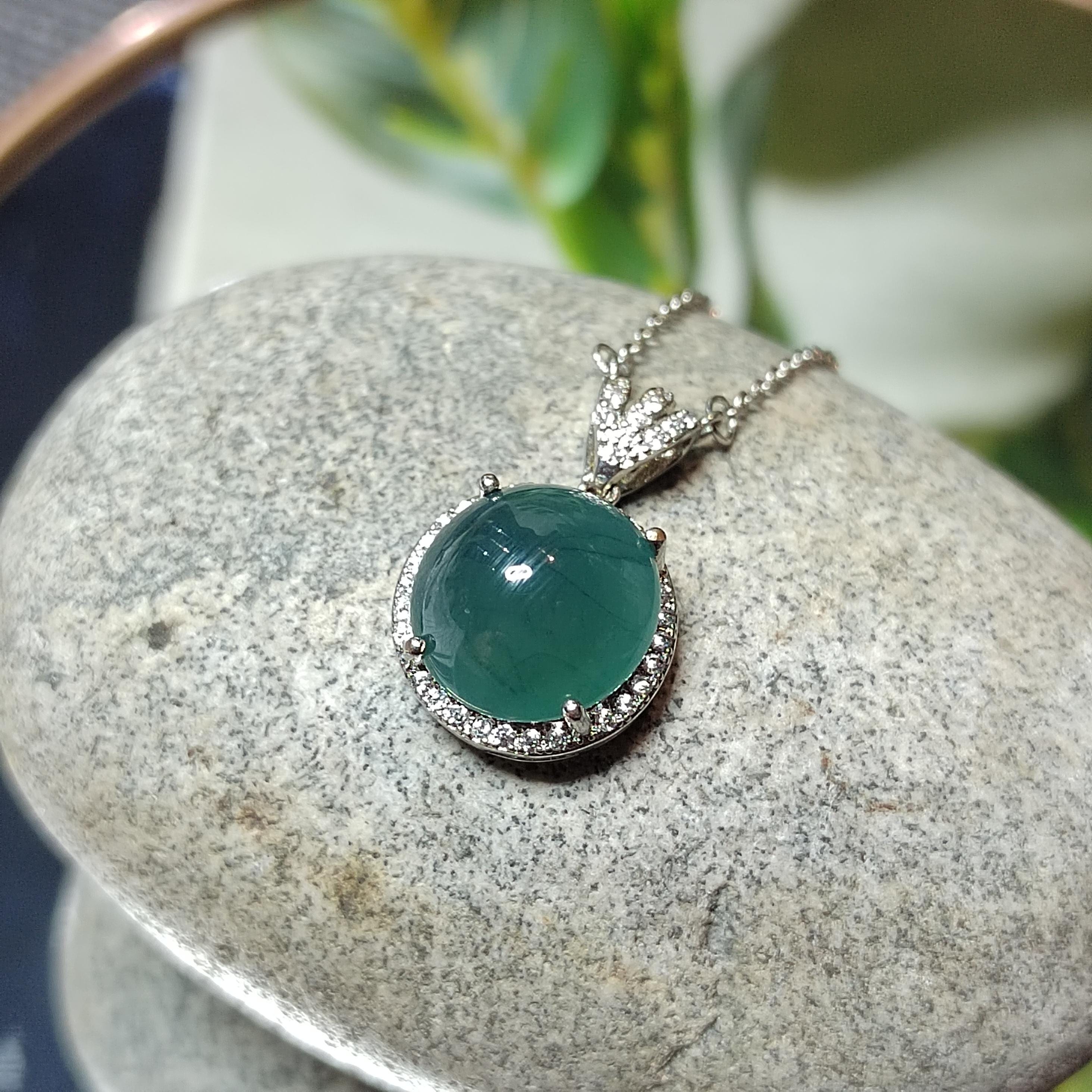 Necklace with a green pendant on a stone surface
