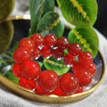 Red berry bracelet on a decorative plate with green leaves