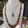Necklace with colorful beads and a pendant on a mannequin bust.