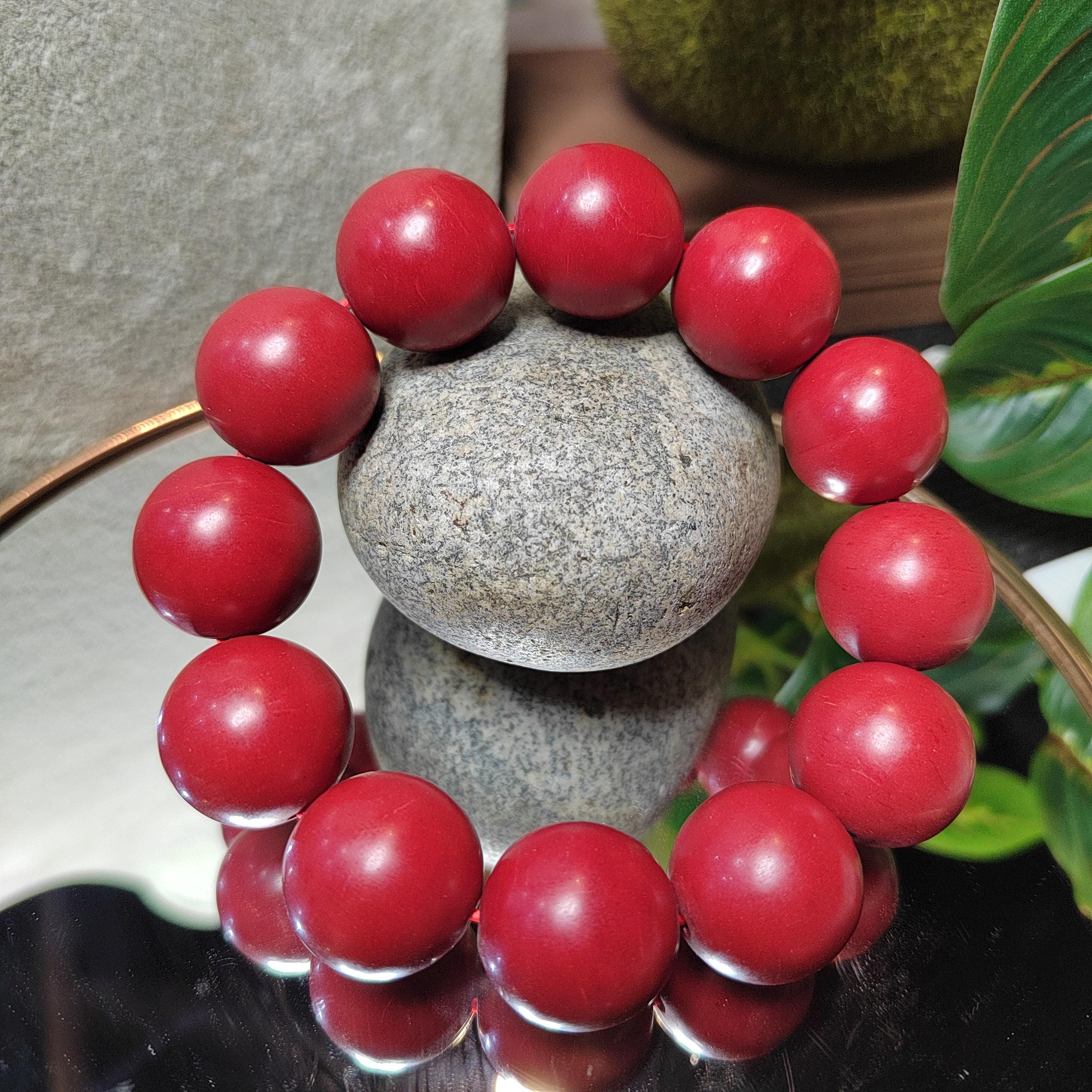 Red beaded bracelet on a stone surface with a natural background