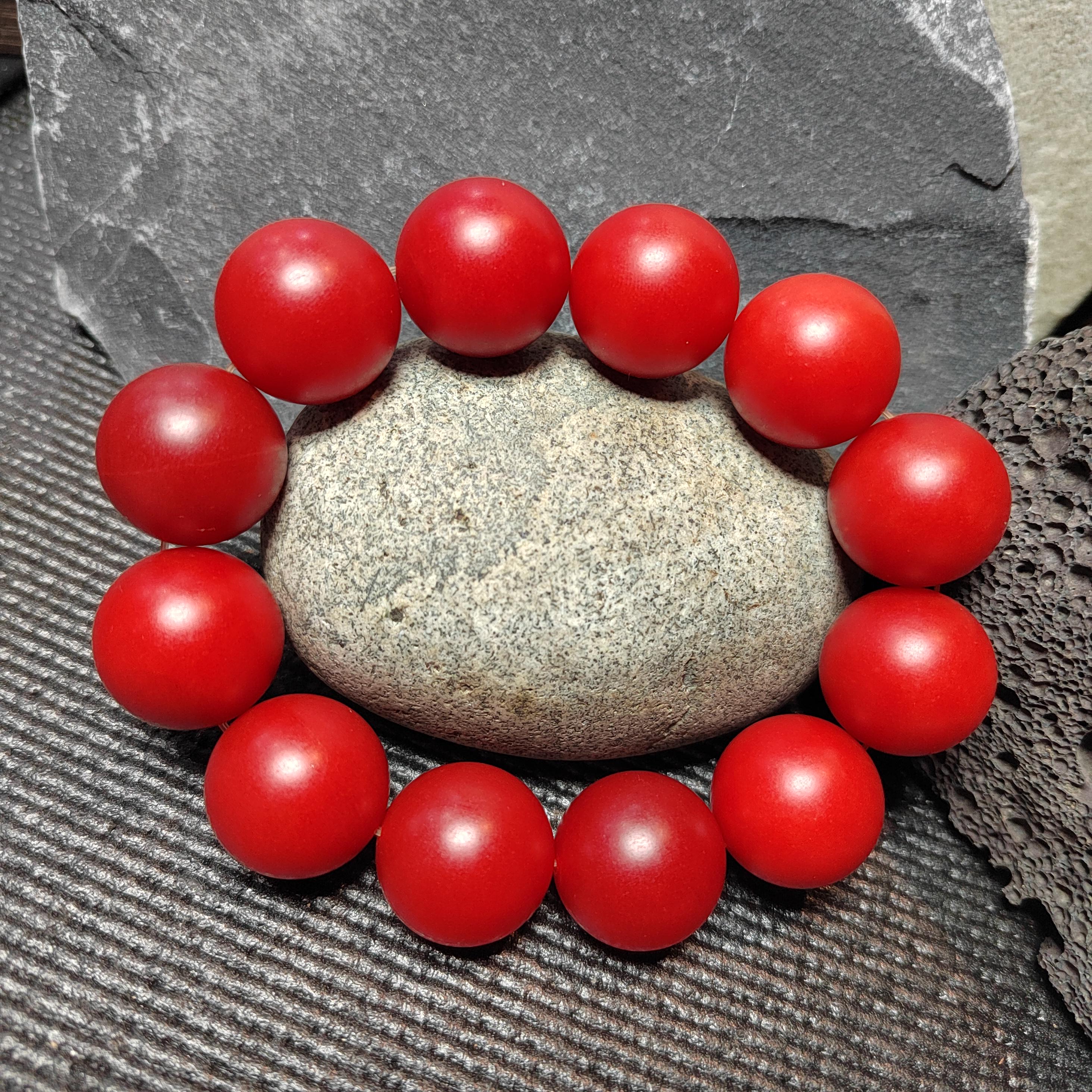 Red beaded bracelet on a stone surface