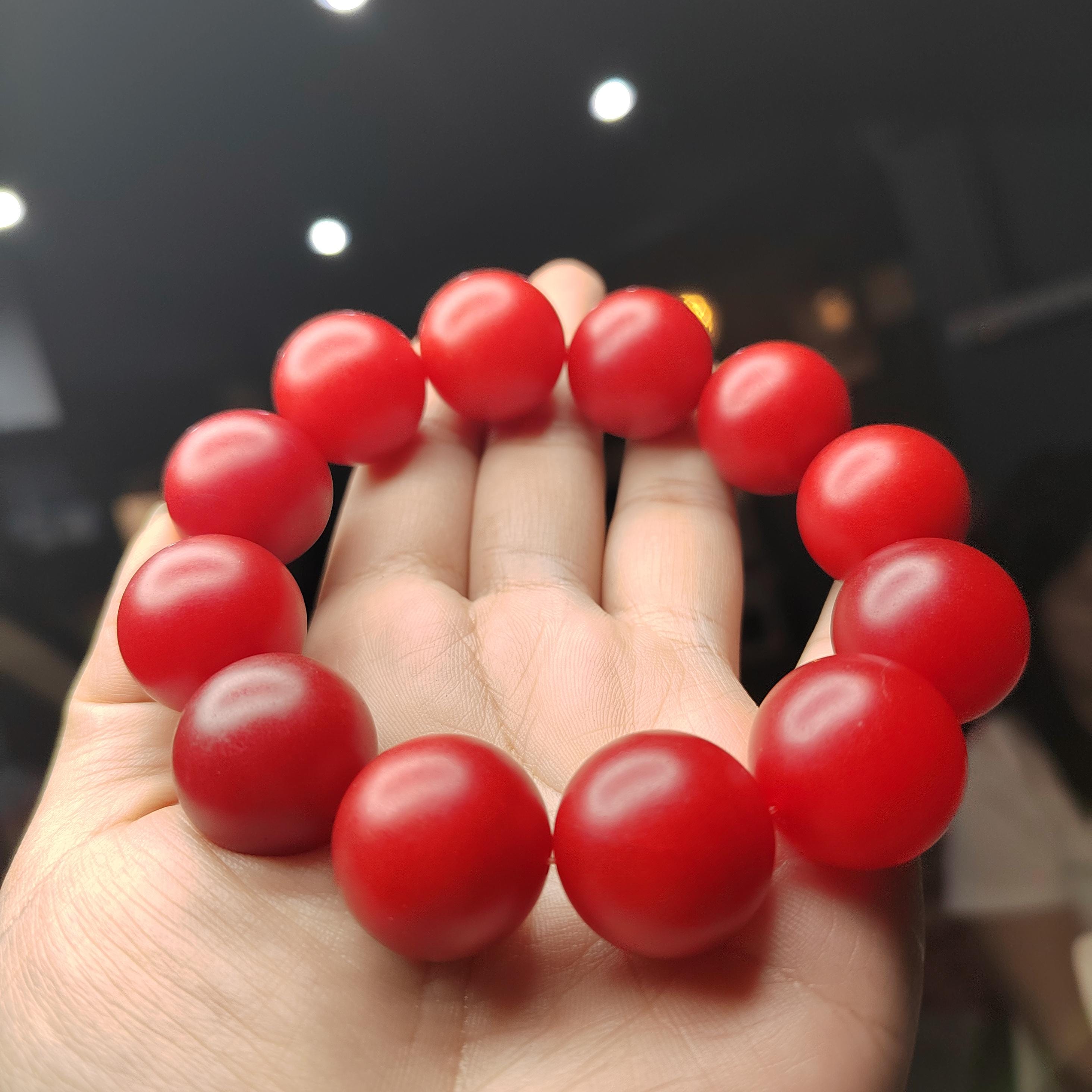 Red beaded bracelet on a hand with a blurred background