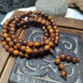 Wooden beaded bracelet on a wooden block with engraved design