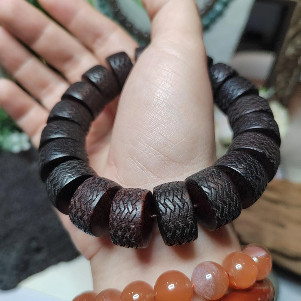 Wooden beaded bracelet on a hand with a blurred background