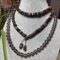 Beaded necklace and earrings on a mannequin bust with a blurred background
