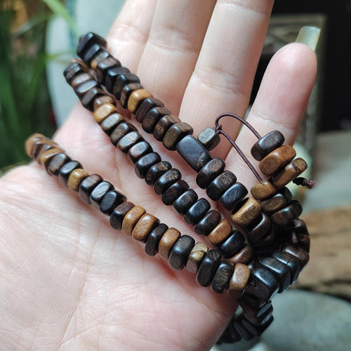 Wooden beaded bracelets on a hand with a blurred background