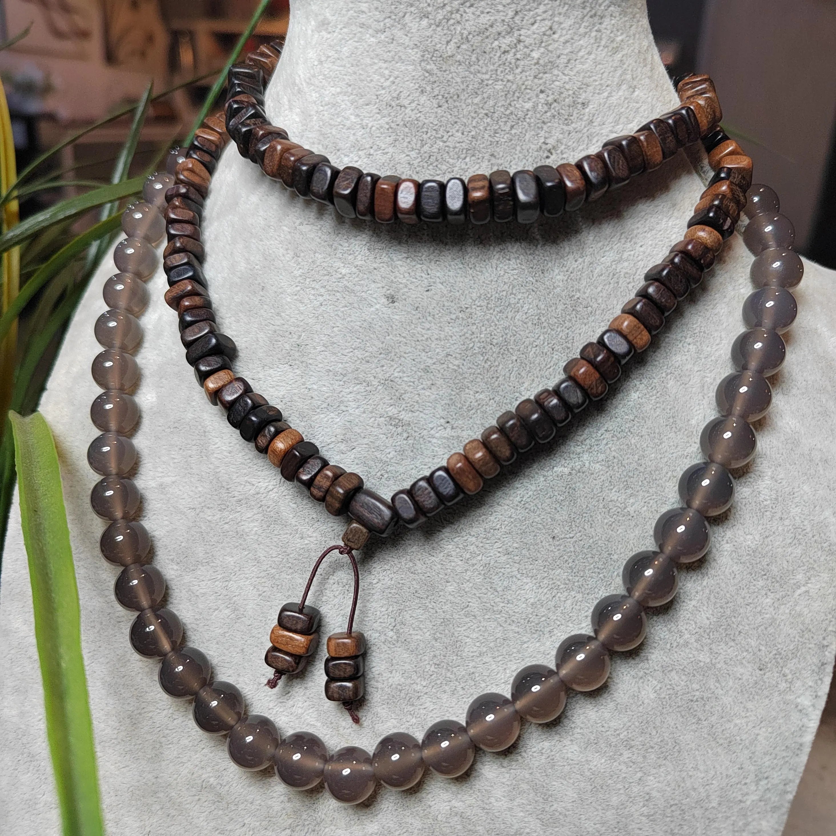 Beaded necklace and earrings on a mannequin bust with a blurred background