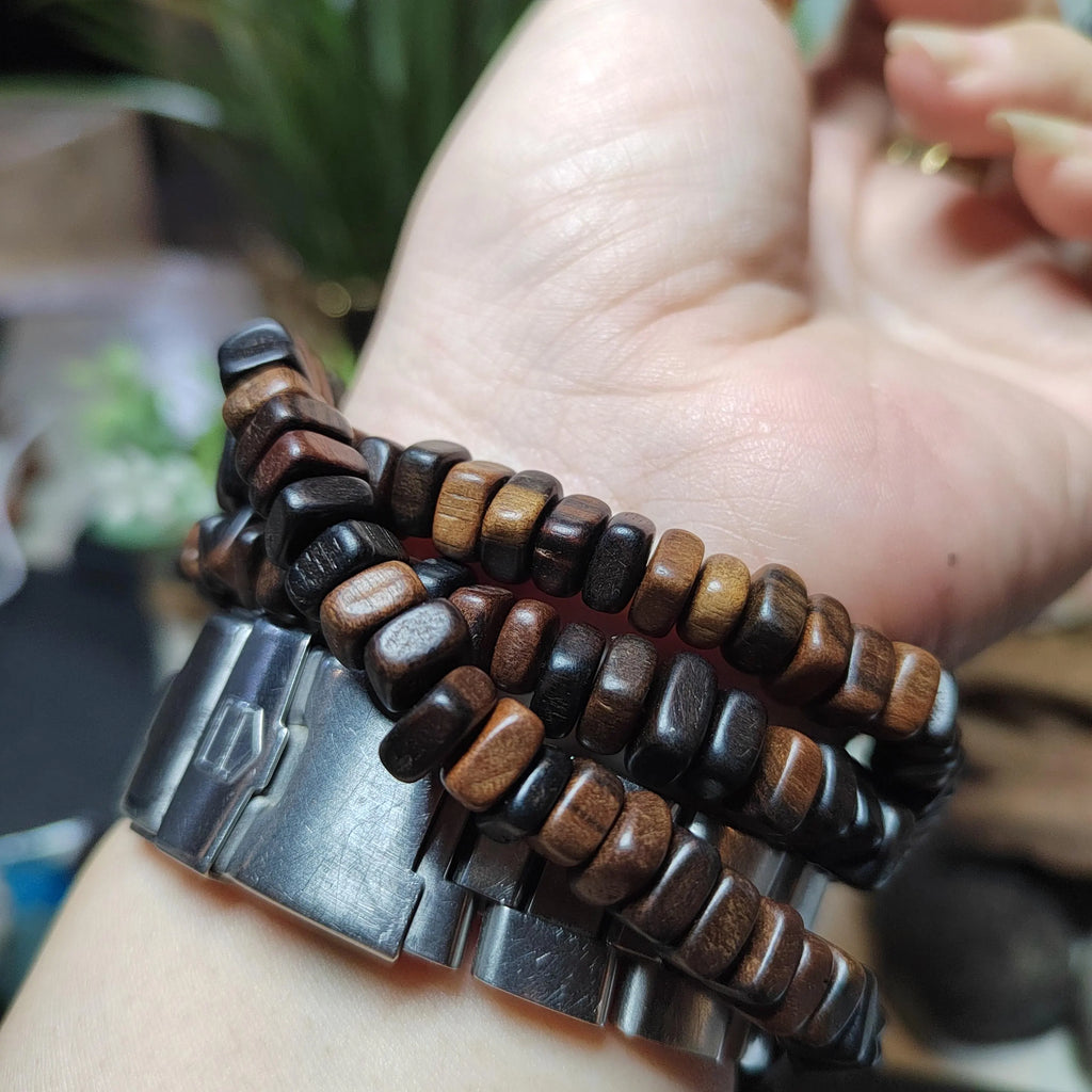Wooden beaded bracelets on a wrist with a blurred background