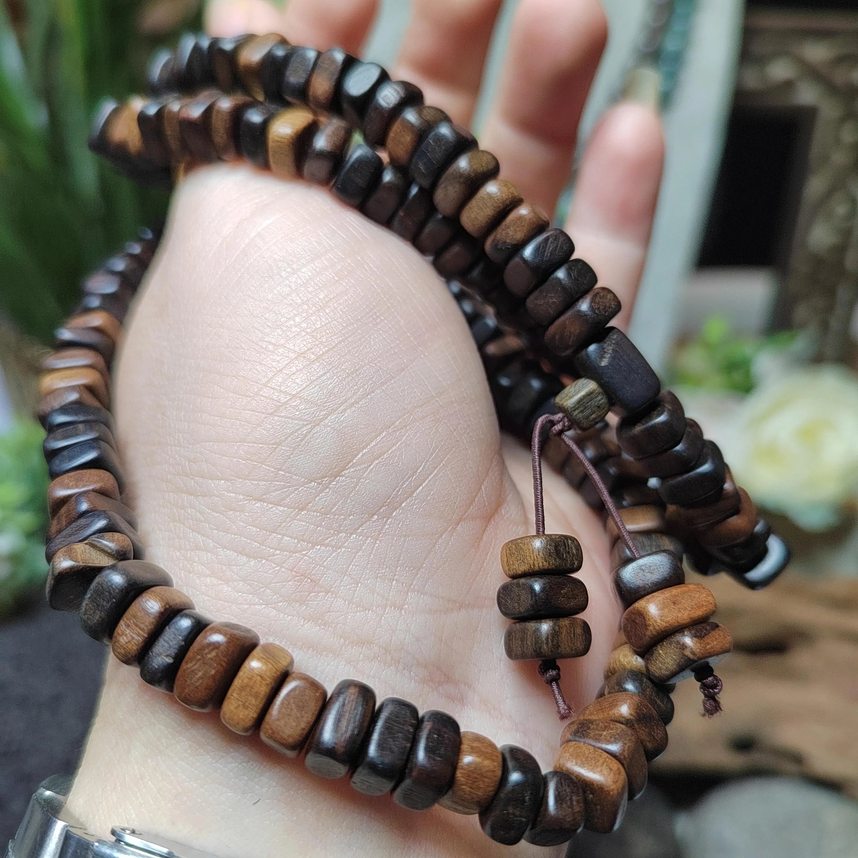 Wooden beaded bracelet on a wrist with a blurred background