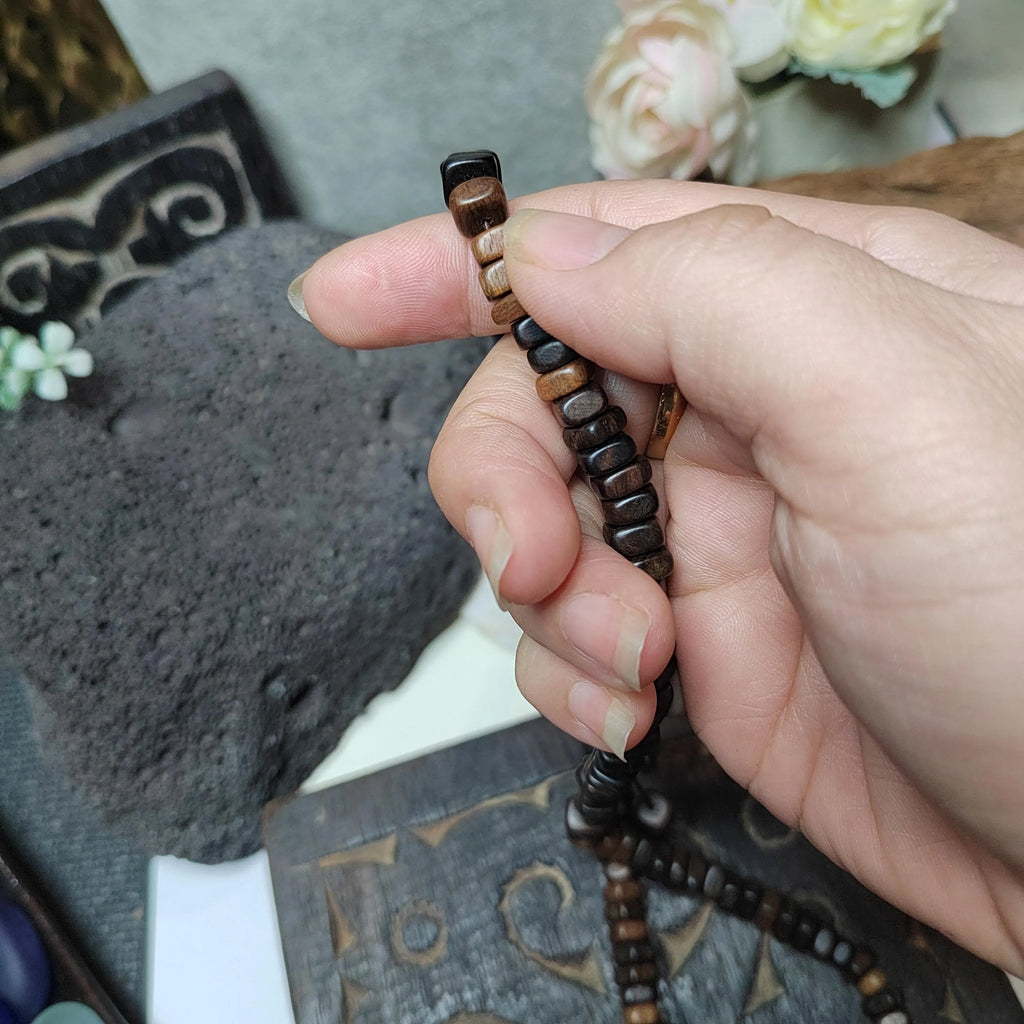 Hand holding a wooden bracelet with a blurred background