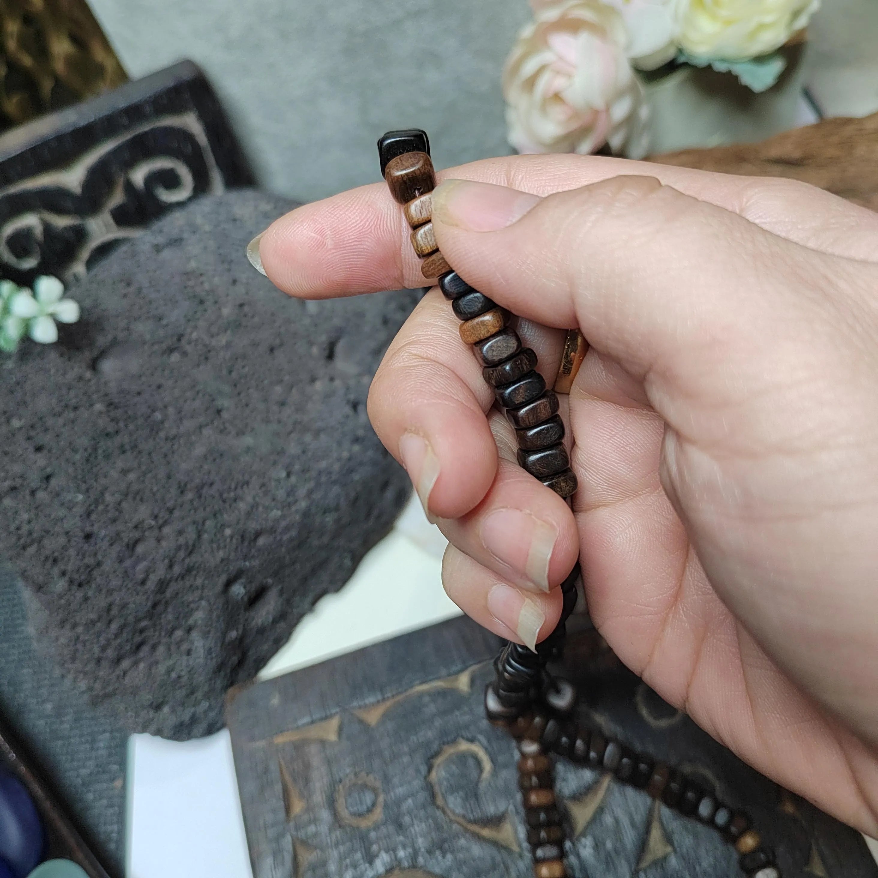 Hand holding a wooden bracelet with a blurred background