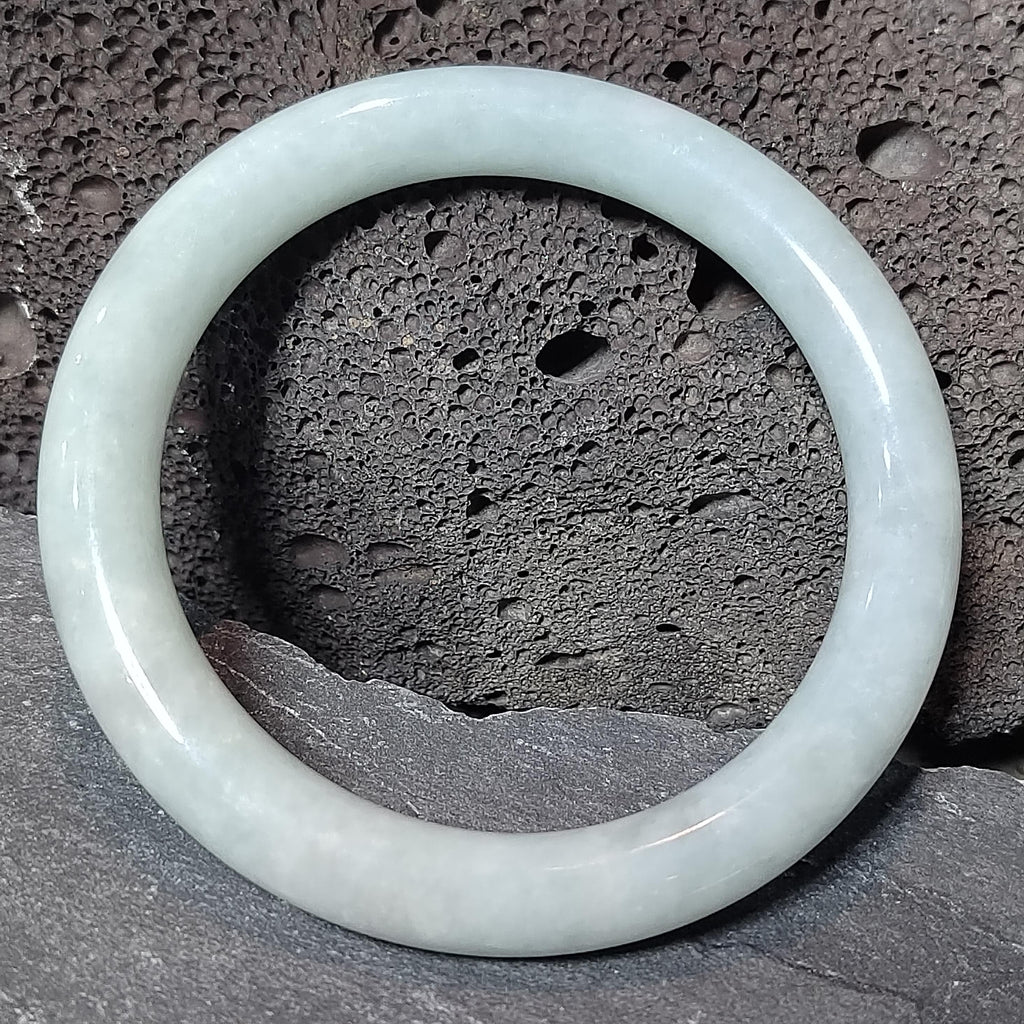 Translucent jade bracelet on a textured stone surface