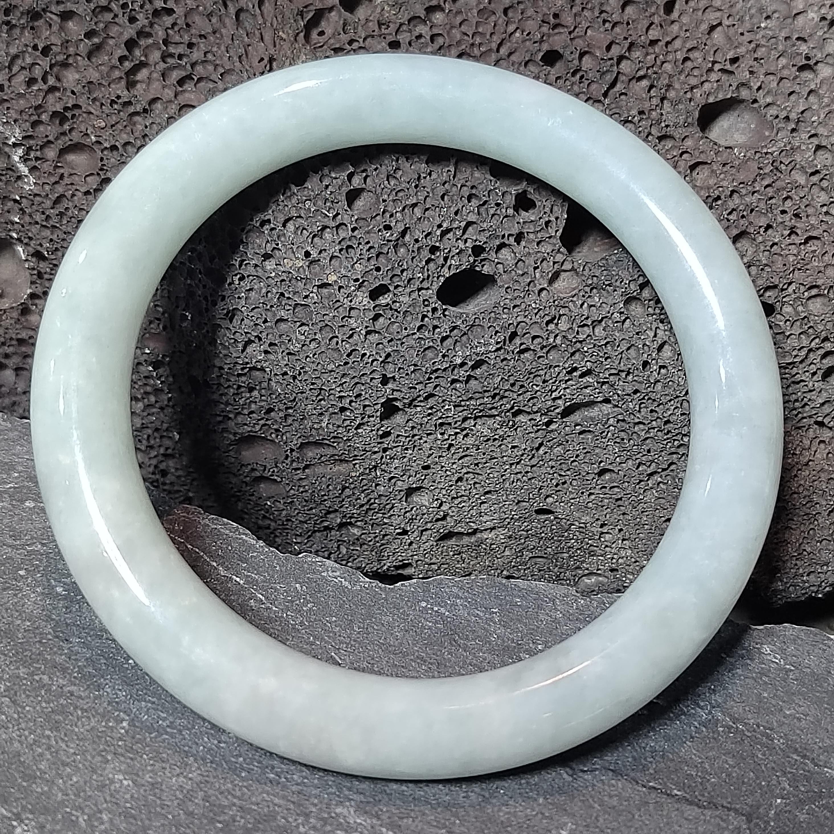 Translucent jade bracelet on a textured stone surface