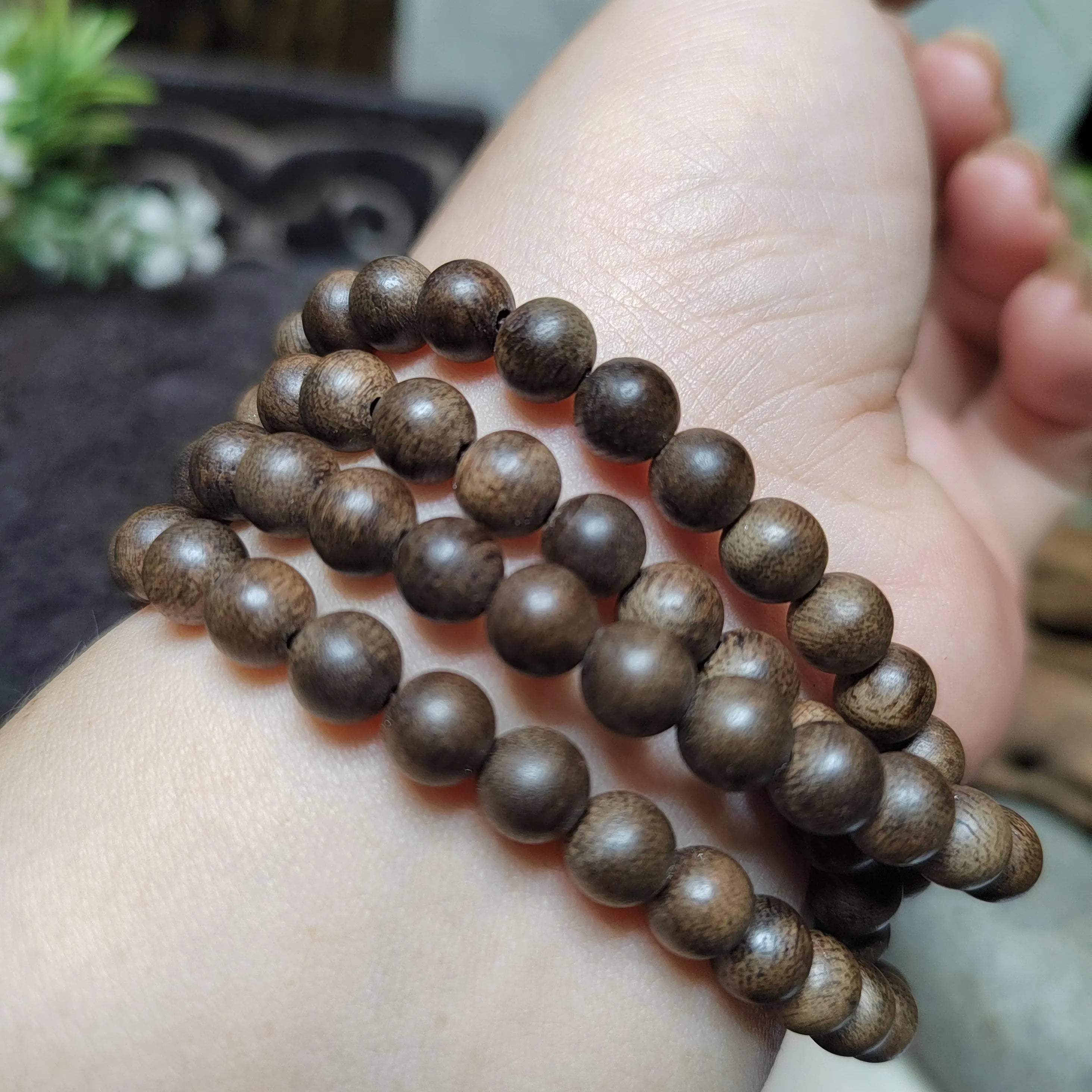 Wooden beaded bracelet on a wrist with a blurred background