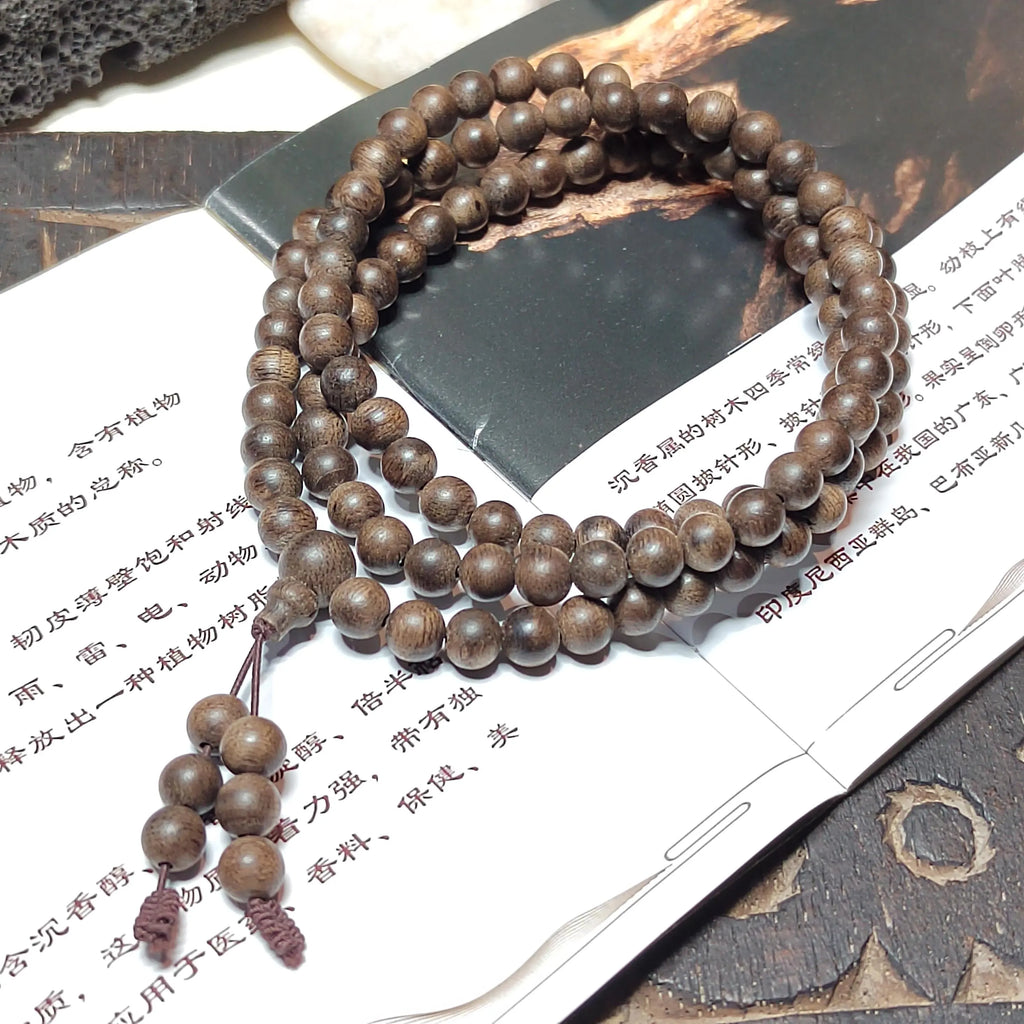 Wooden beaded necklace on a textured surface with text