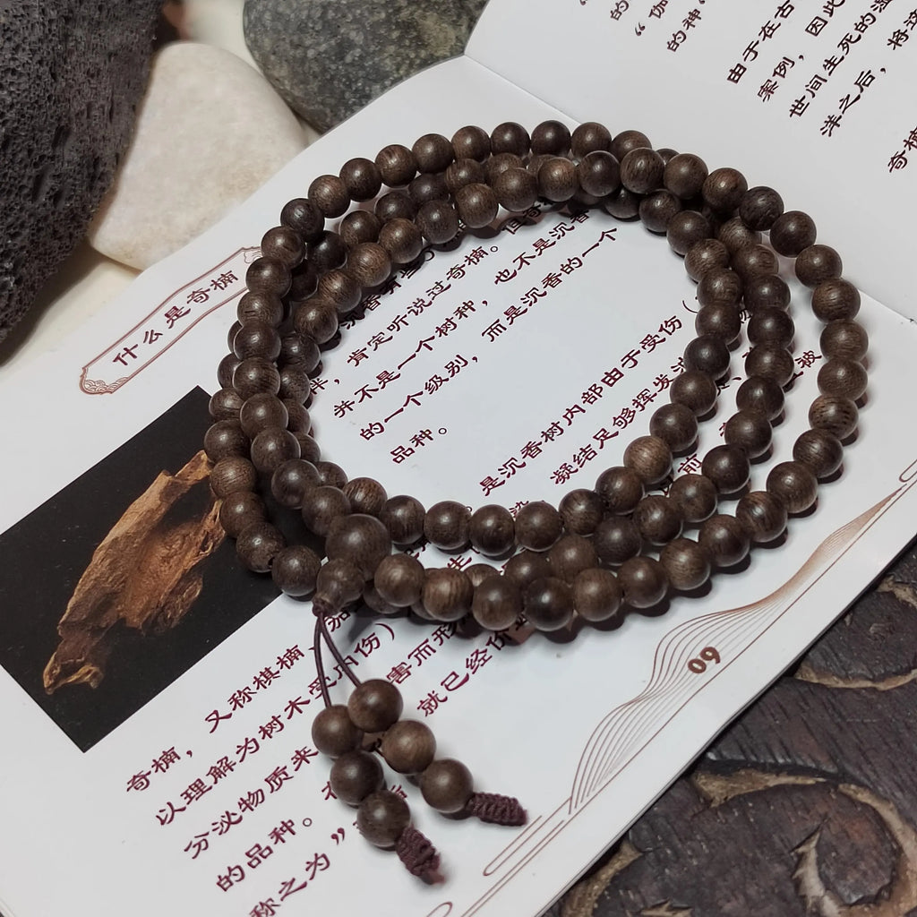 Wooden beaded necklace on a textured surface with text
