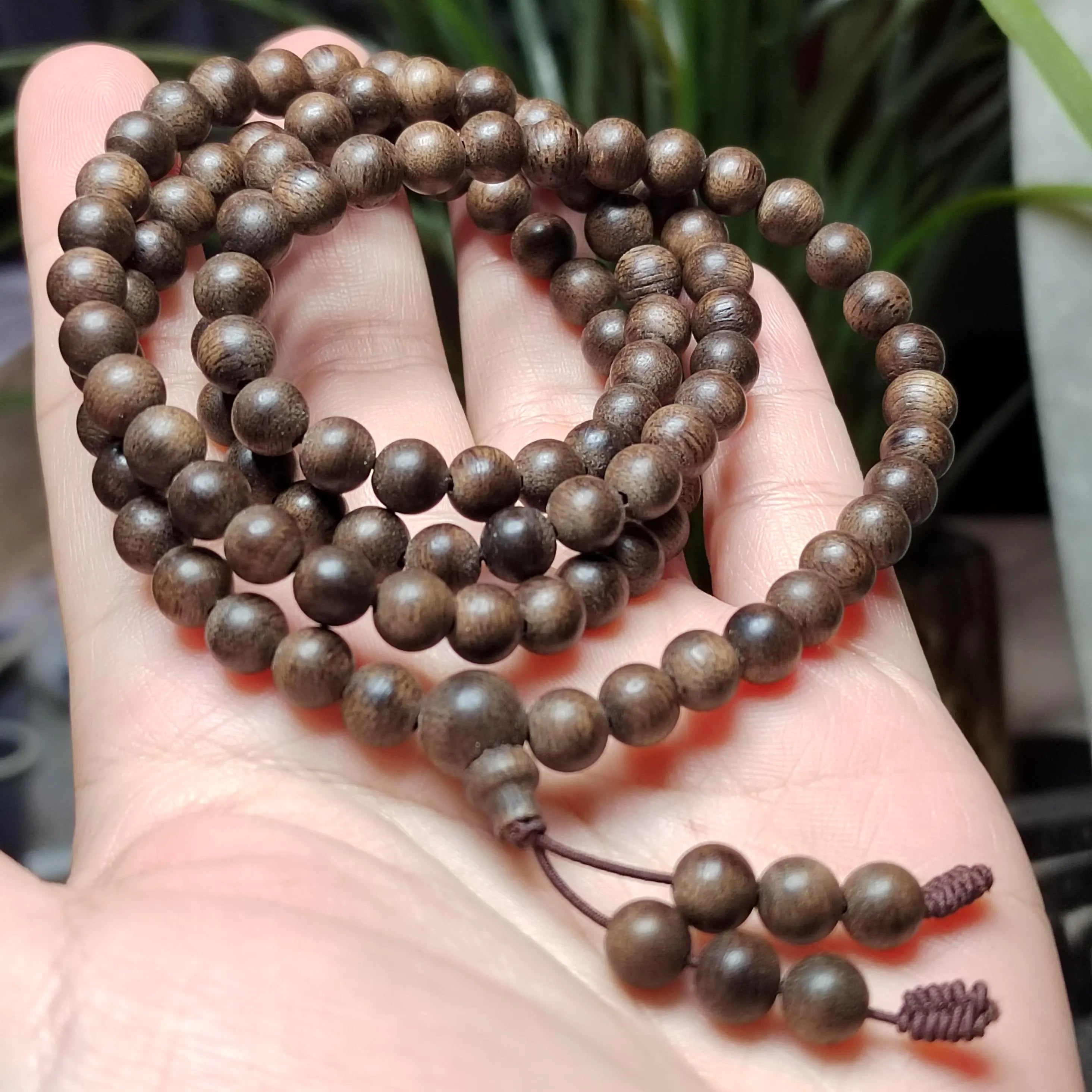Wooden beaded bracelet held in a hand with a blurred background