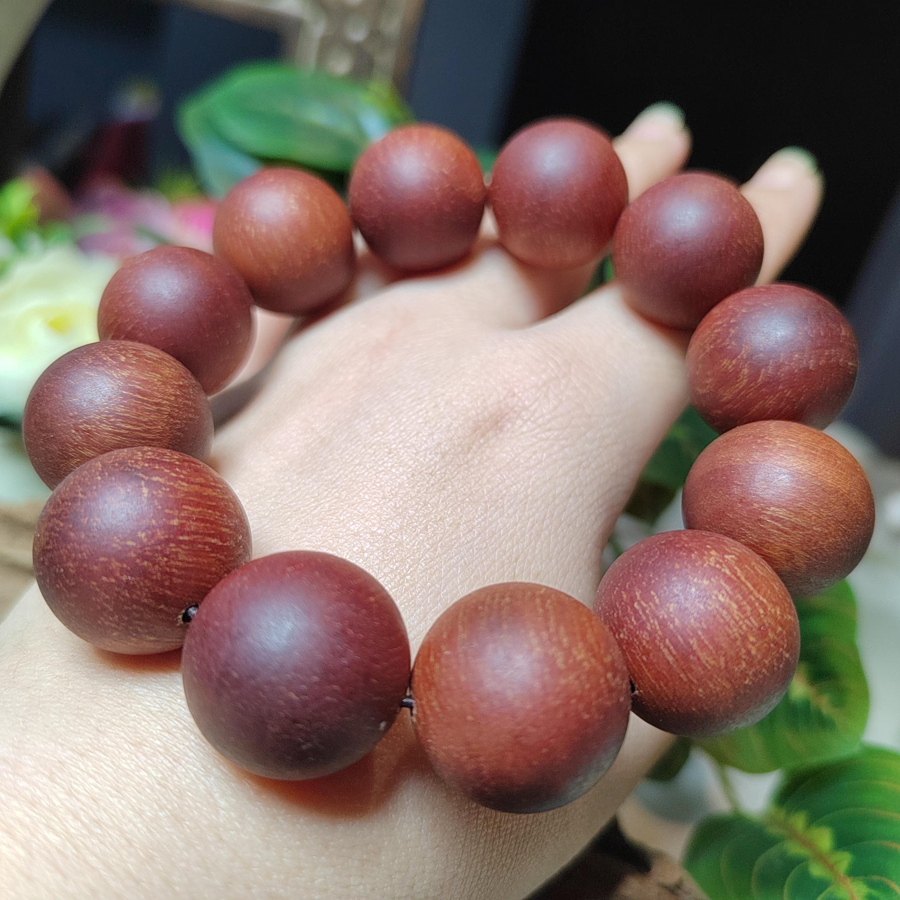 Wooden beaded bracelet on a wrist with a blurred natural background