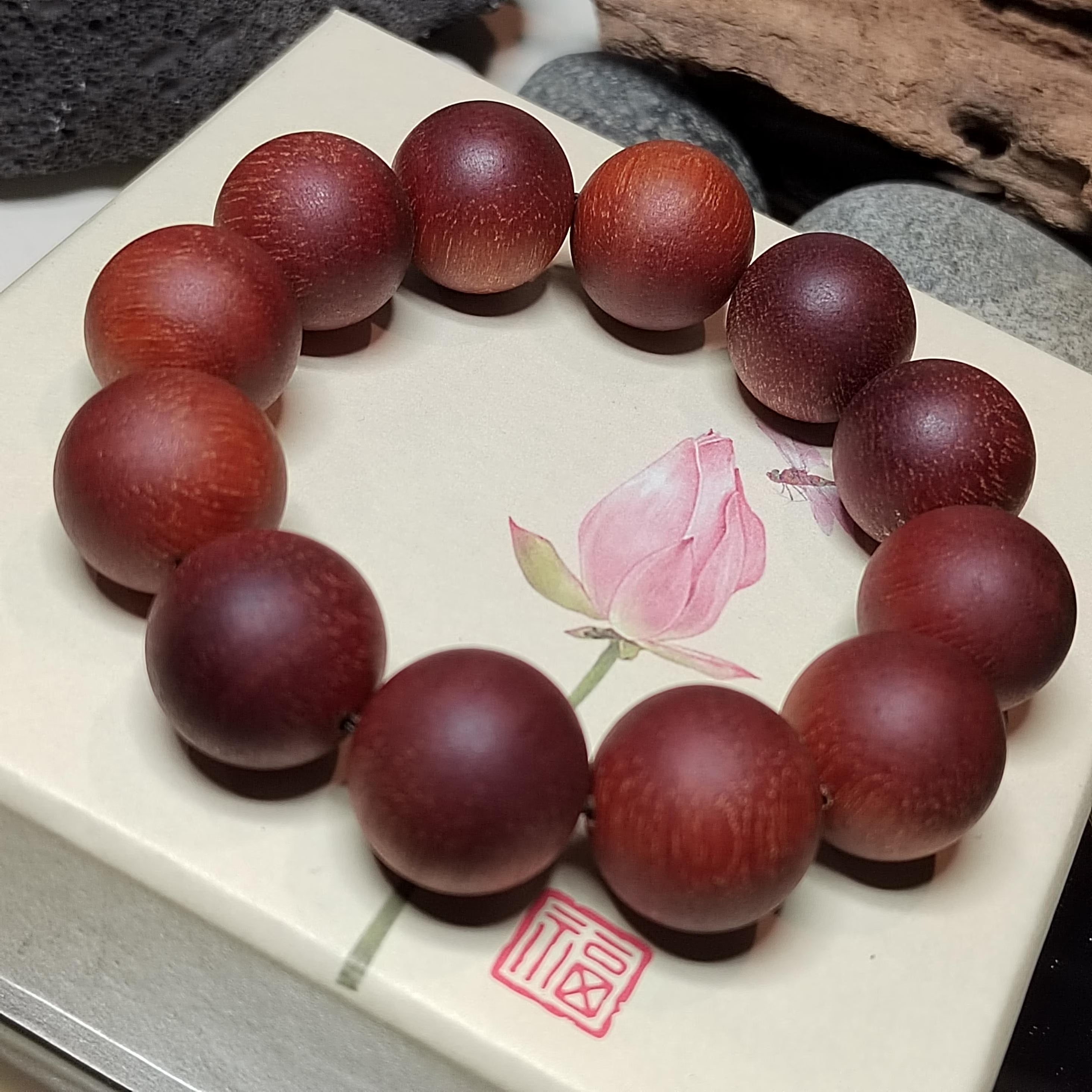 Wooden bead bracelet on a decorative plate with floral design