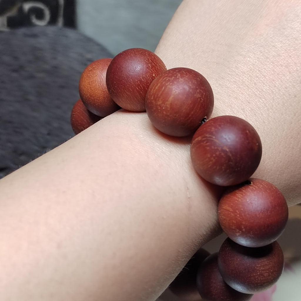 Wooden beaded bracelet on a wrist with a blurred background