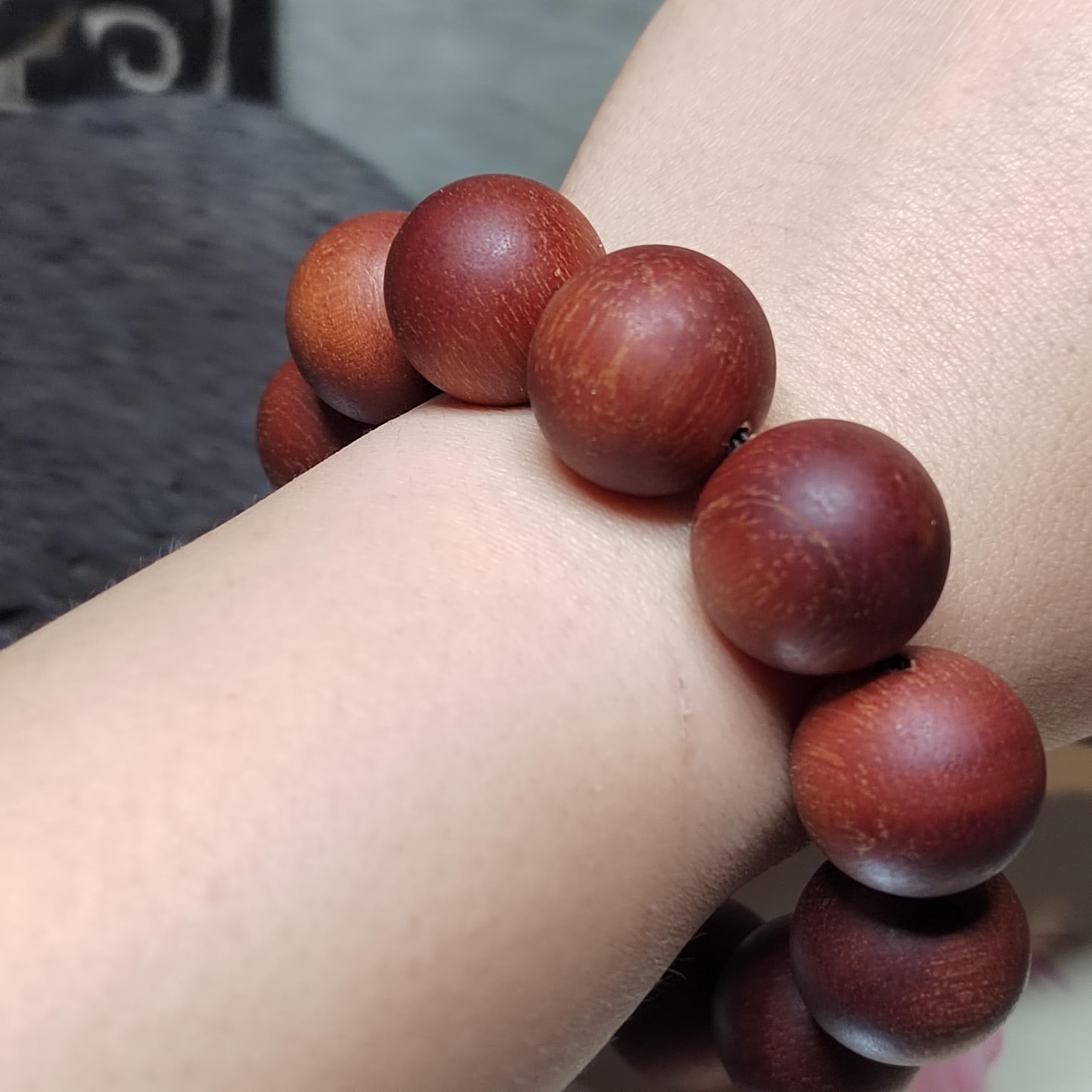 Wooden beaded bracelet on a wrist with a blurred background
