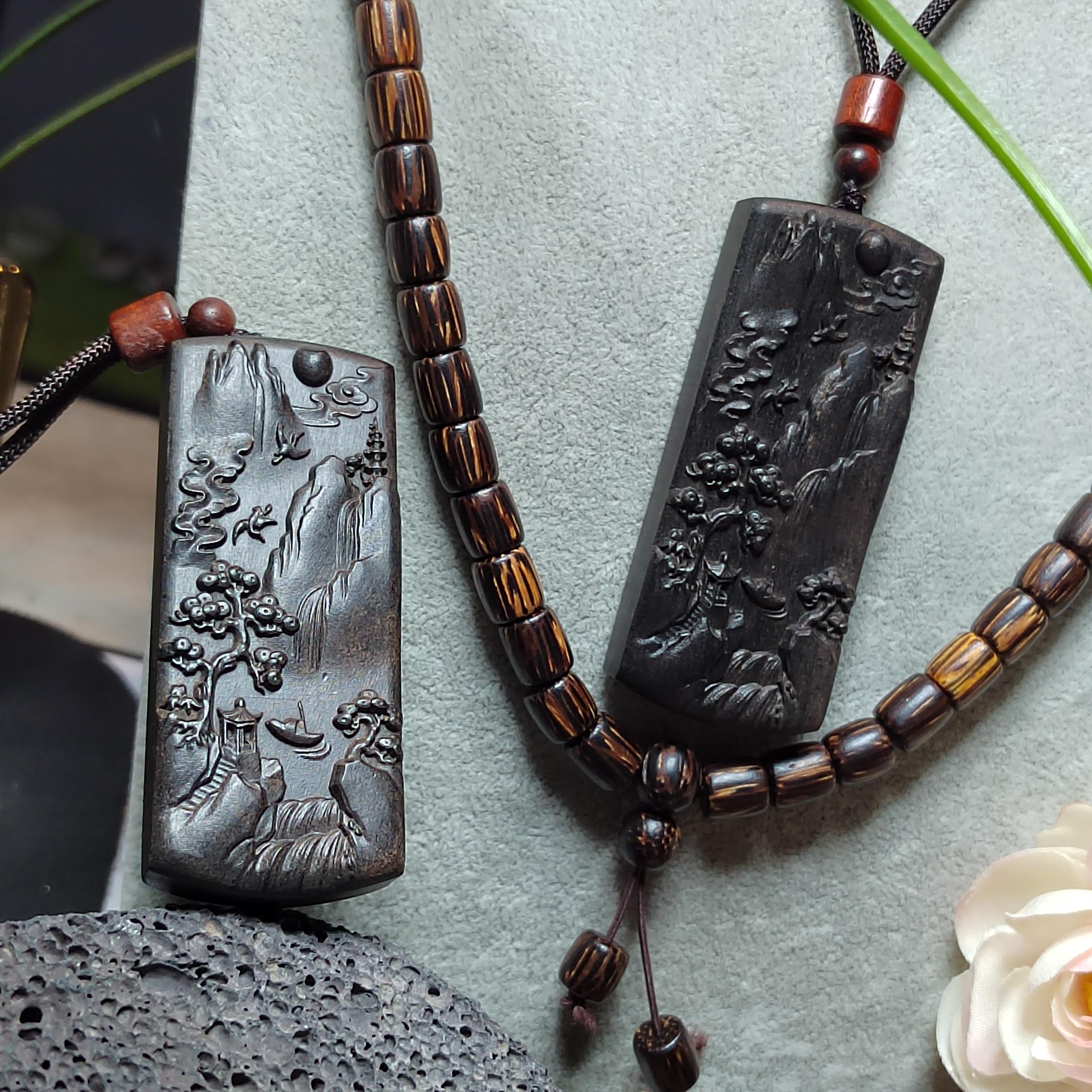 Decorative necklace with engraved pendants on a textured surface