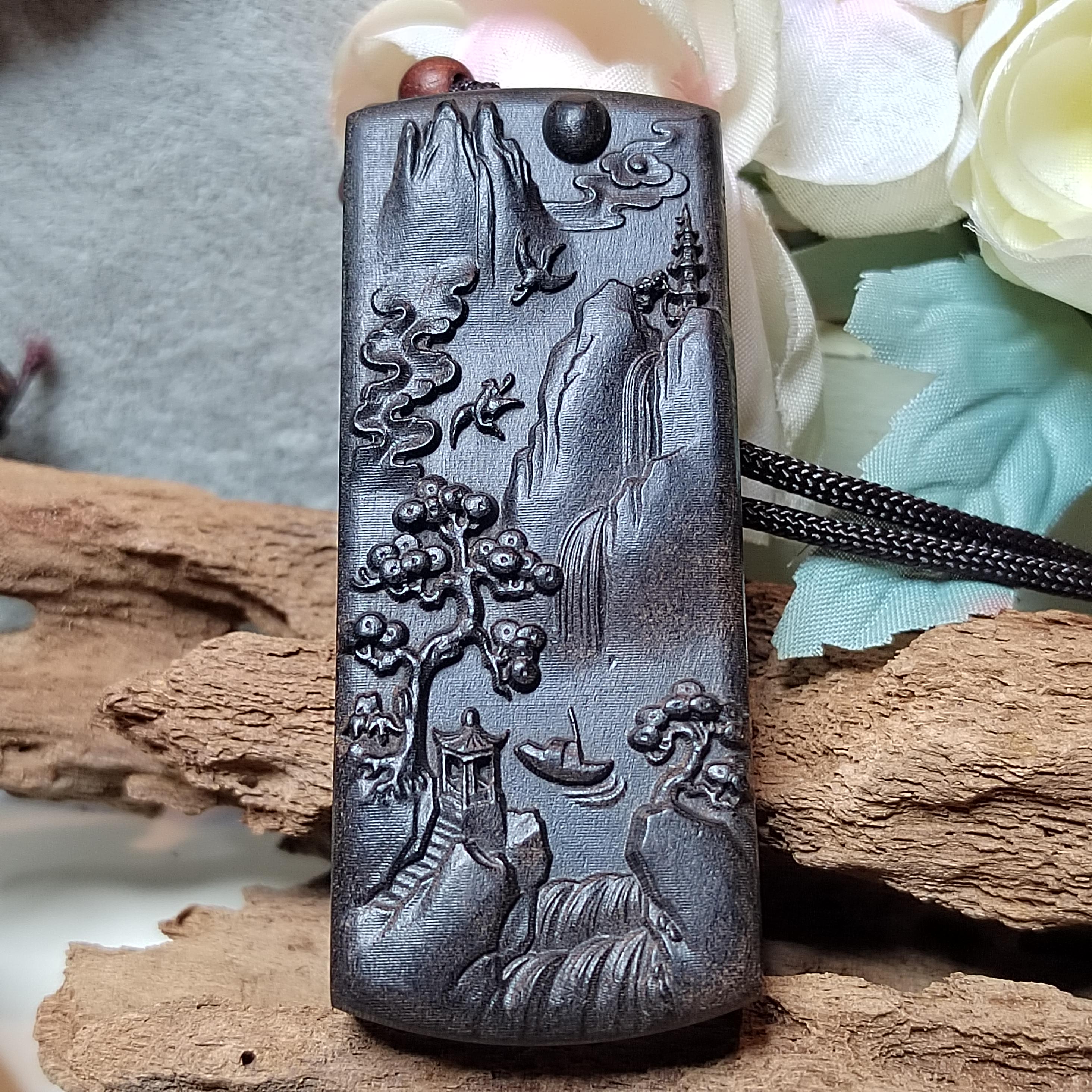 Decorative pendant with mountain and tree design on a natural background