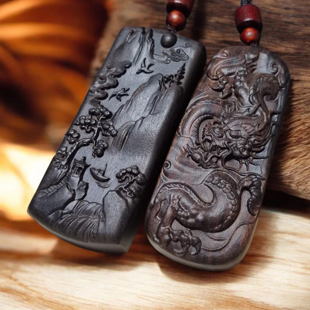 Two intricately carved stone pendants on a wooden surface