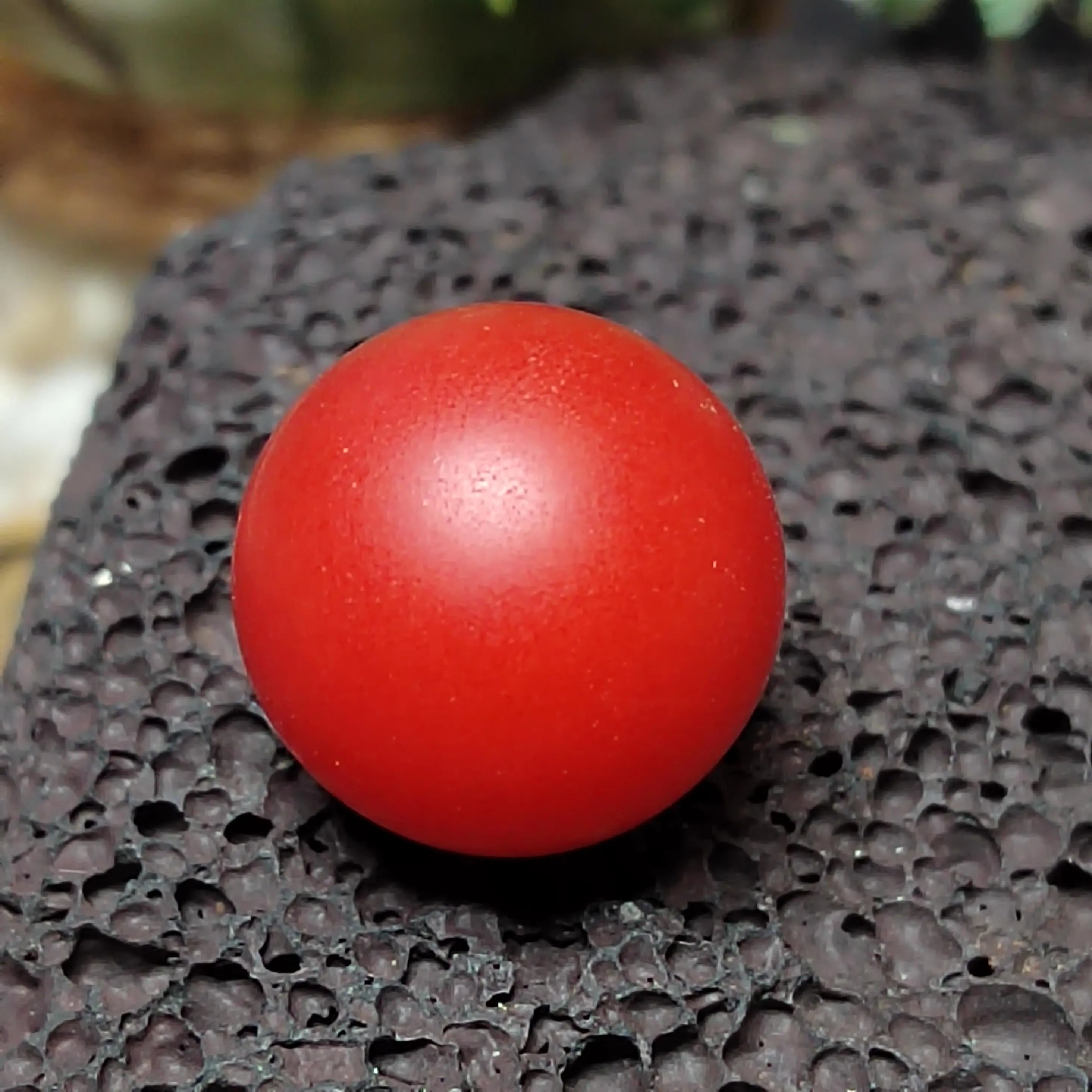 Red ball on a textured black surface