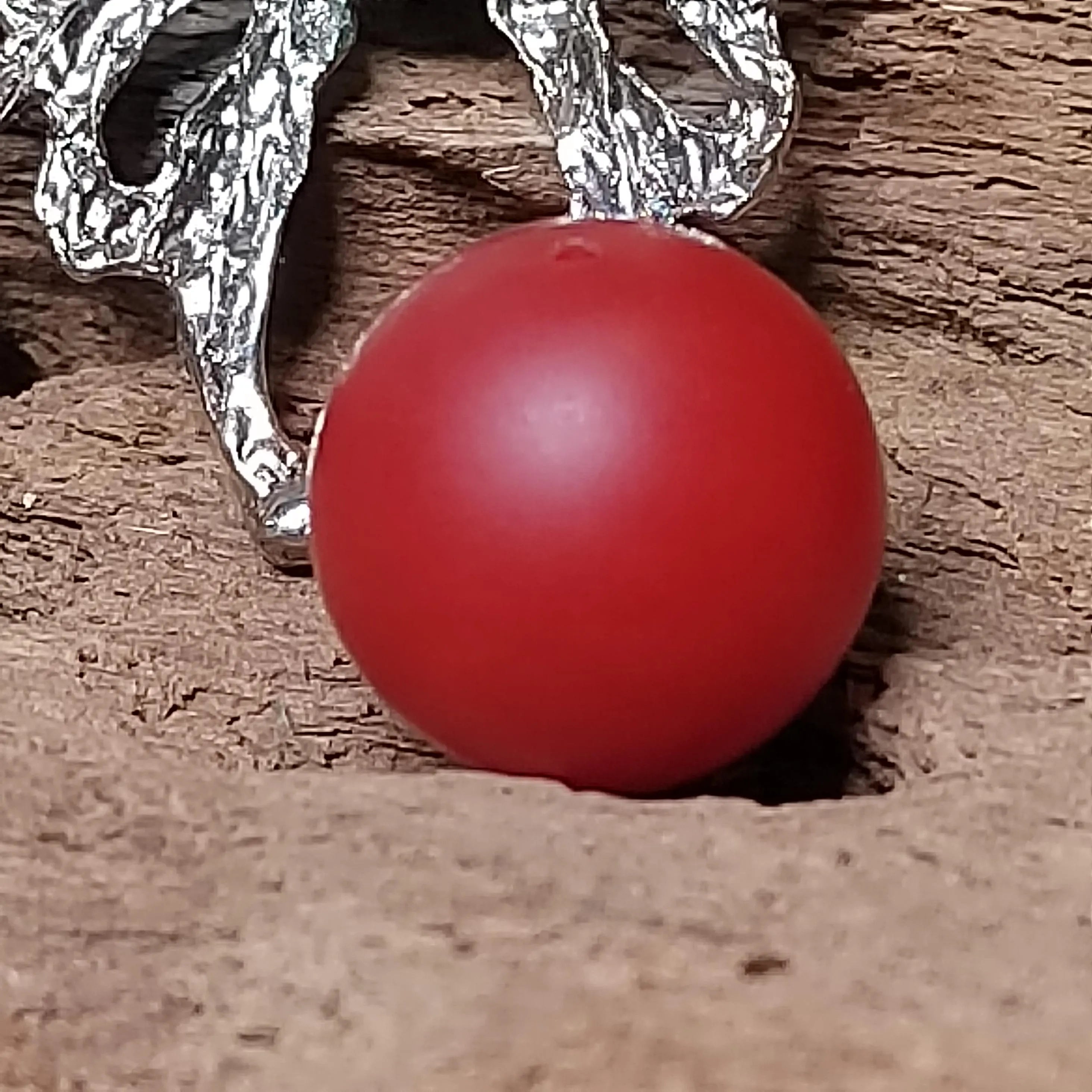 Red Nanhong bead  with a silver chain on a wooden surface