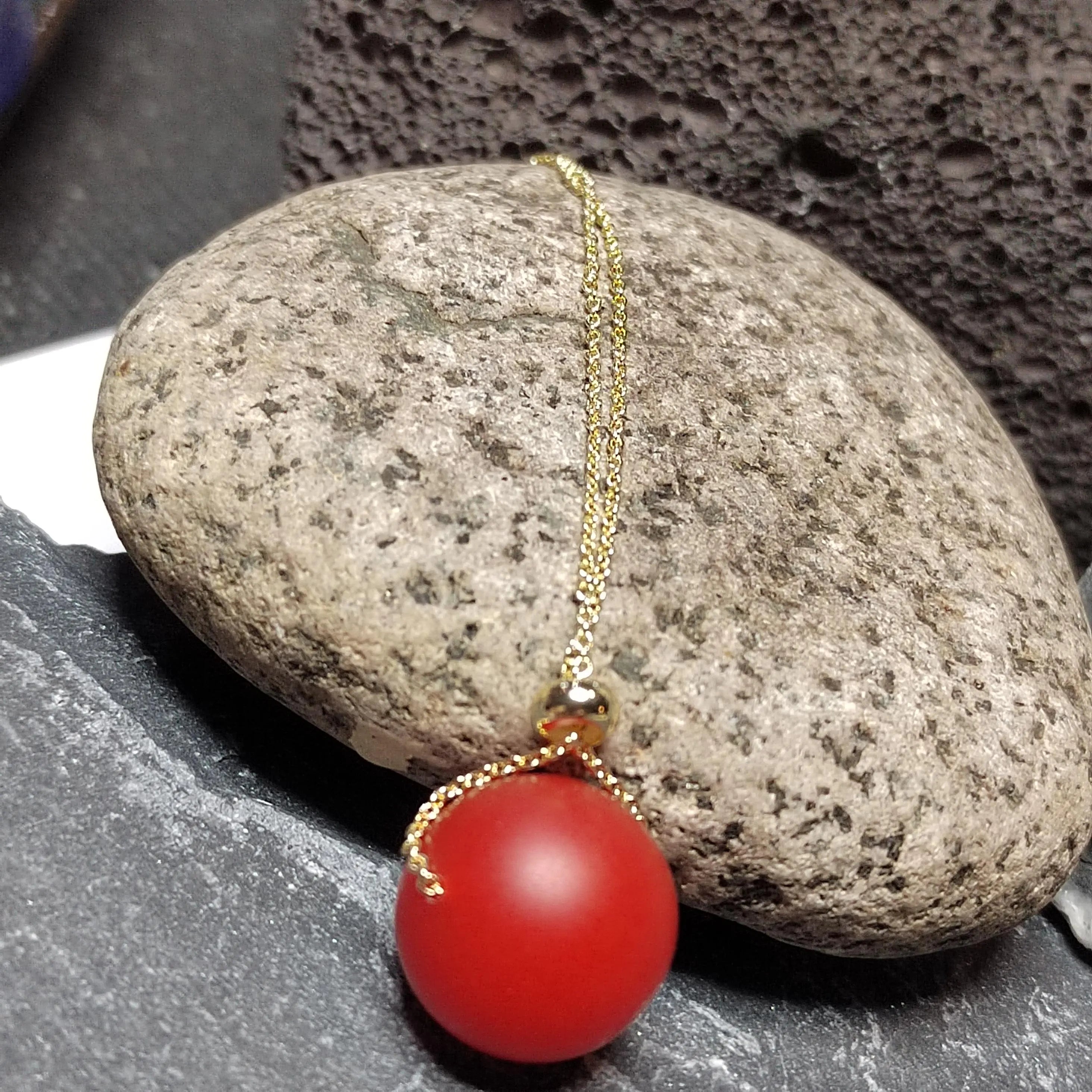 Red bead necklace on a stone surface