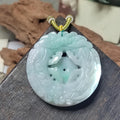 Carved jade pendant on a wooden stand with a blurred background