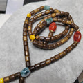 Necklace with brown beads and colorful accents on a gray surface