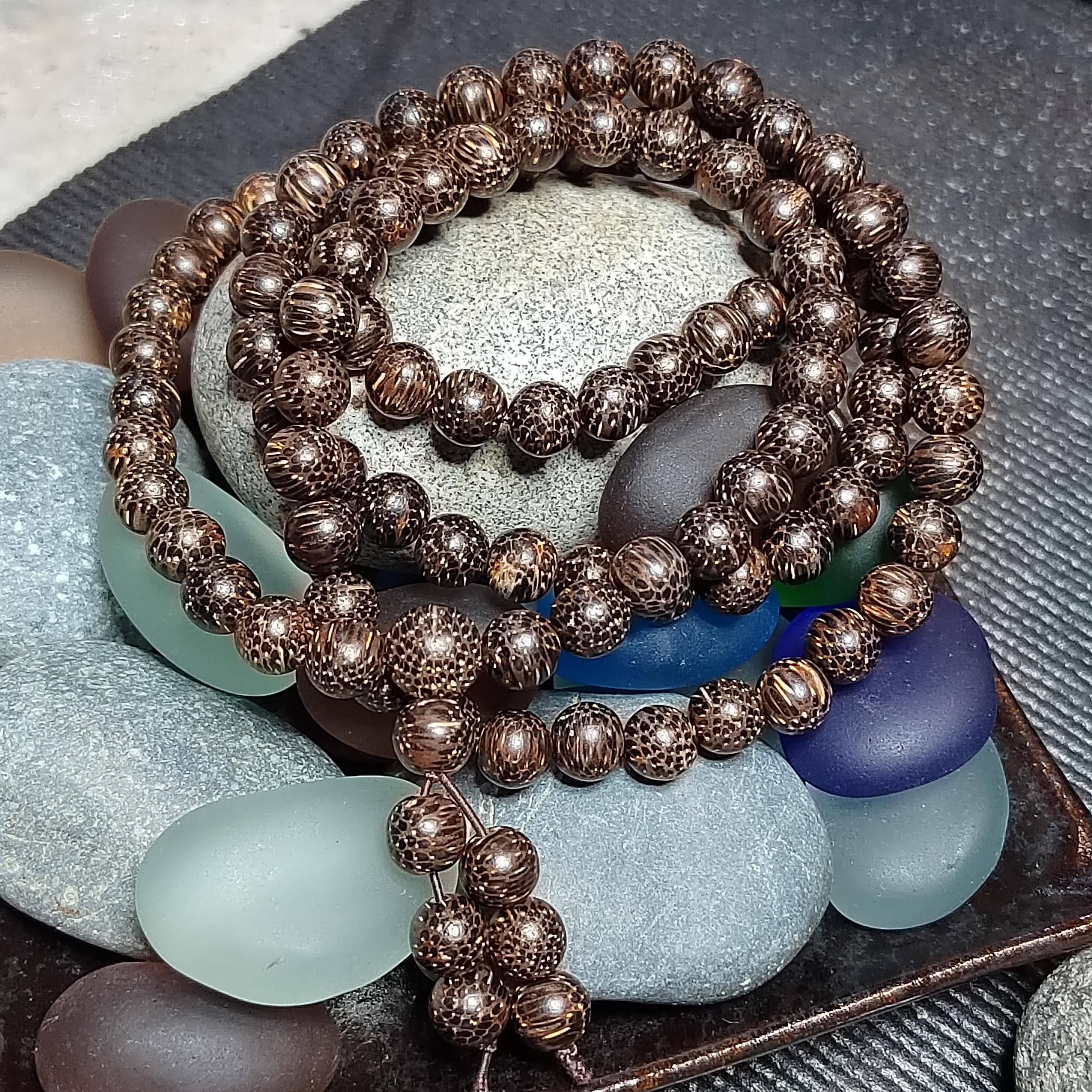 Bronze beaded bracelet on a bed of multicolored stones