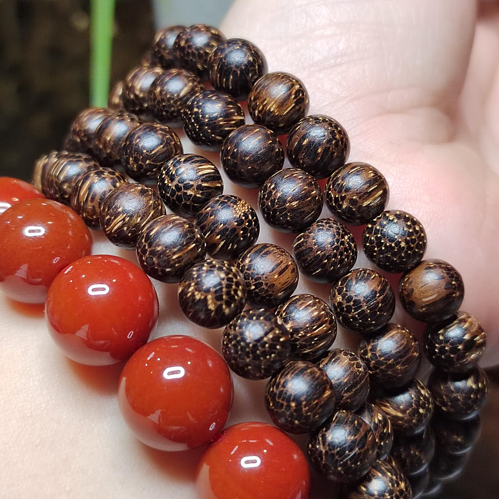 Close-up of a bracelet with brown beaded strands and red spherical stones.