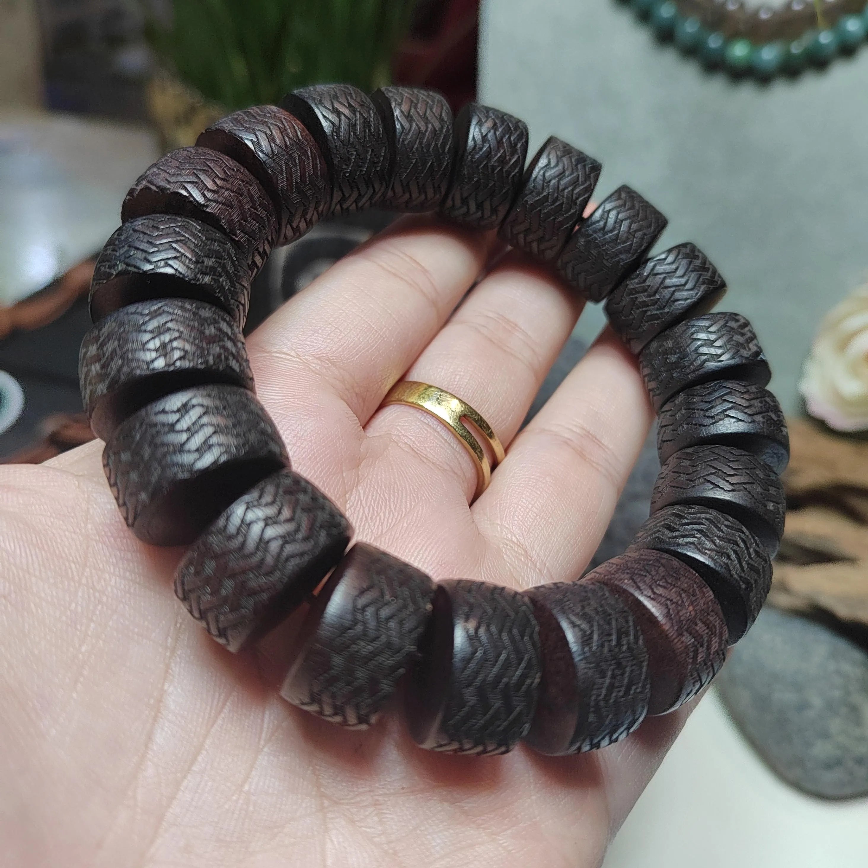 Dark brown textured bracelet on a hand with a blurred background