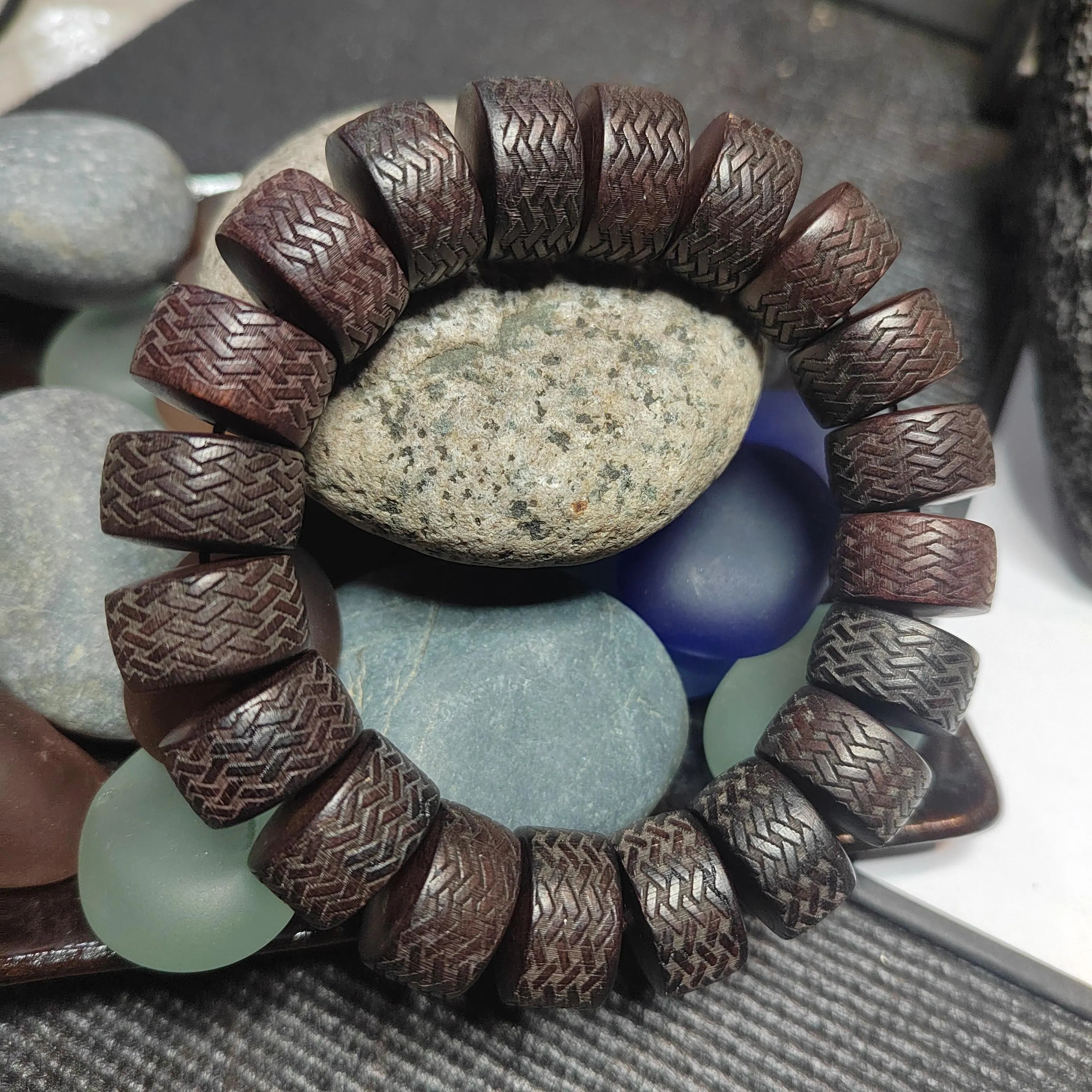 Brown textured bracelet on a bed of stones