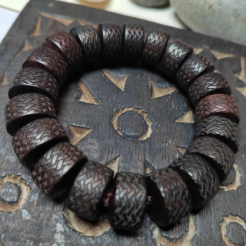 Wooden bracelet with textured beads on a wooden surface