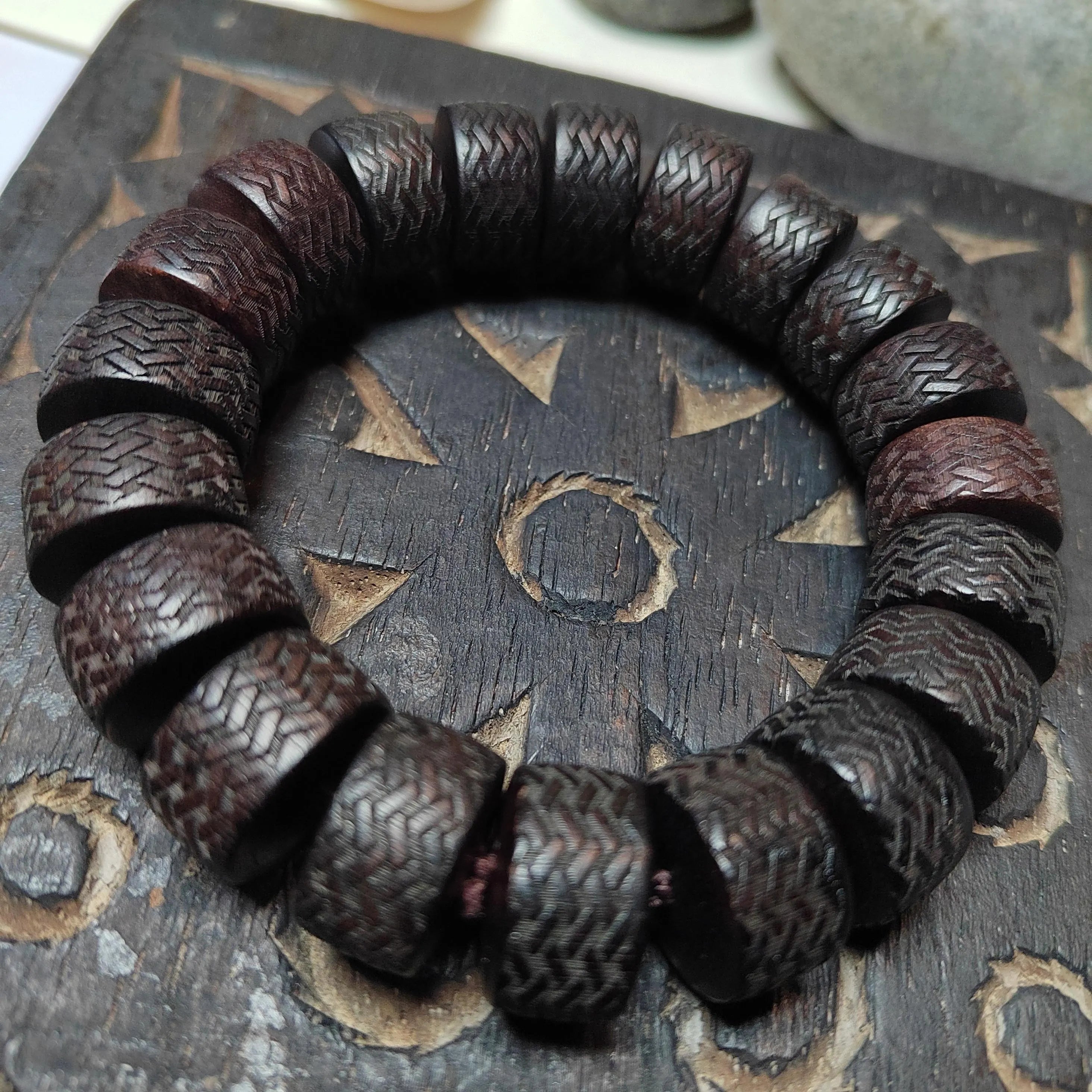 Wooden bracelet with textured beads on a wooden surface
