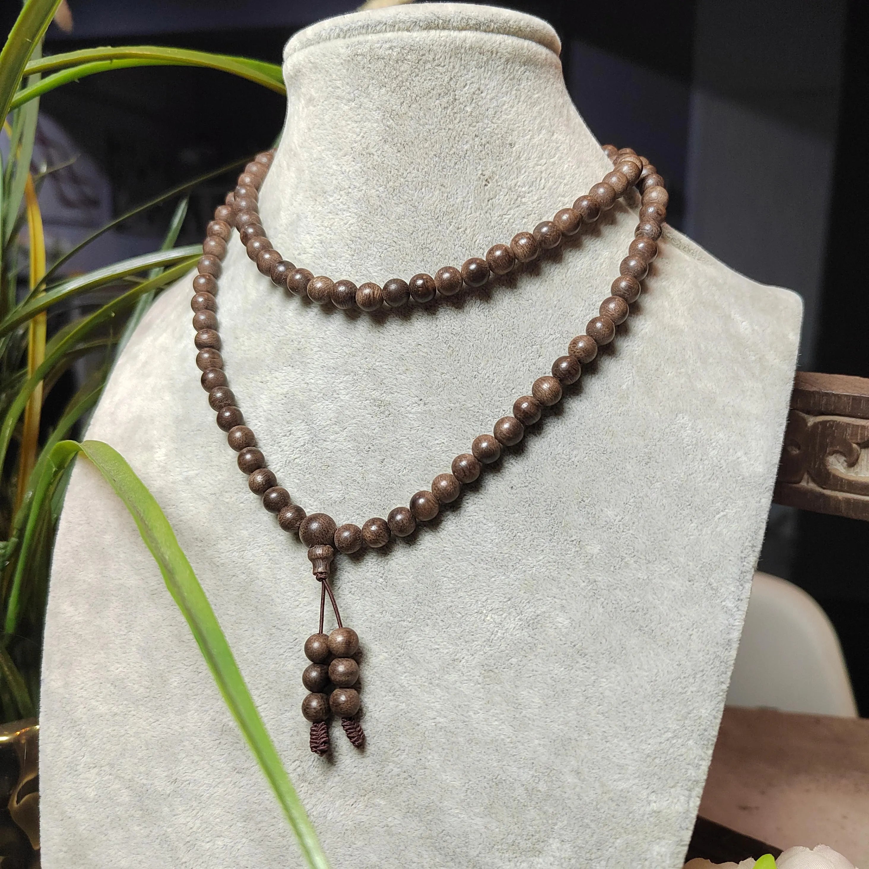 Brown beaded necklace on a mannequin bust with a blurred background