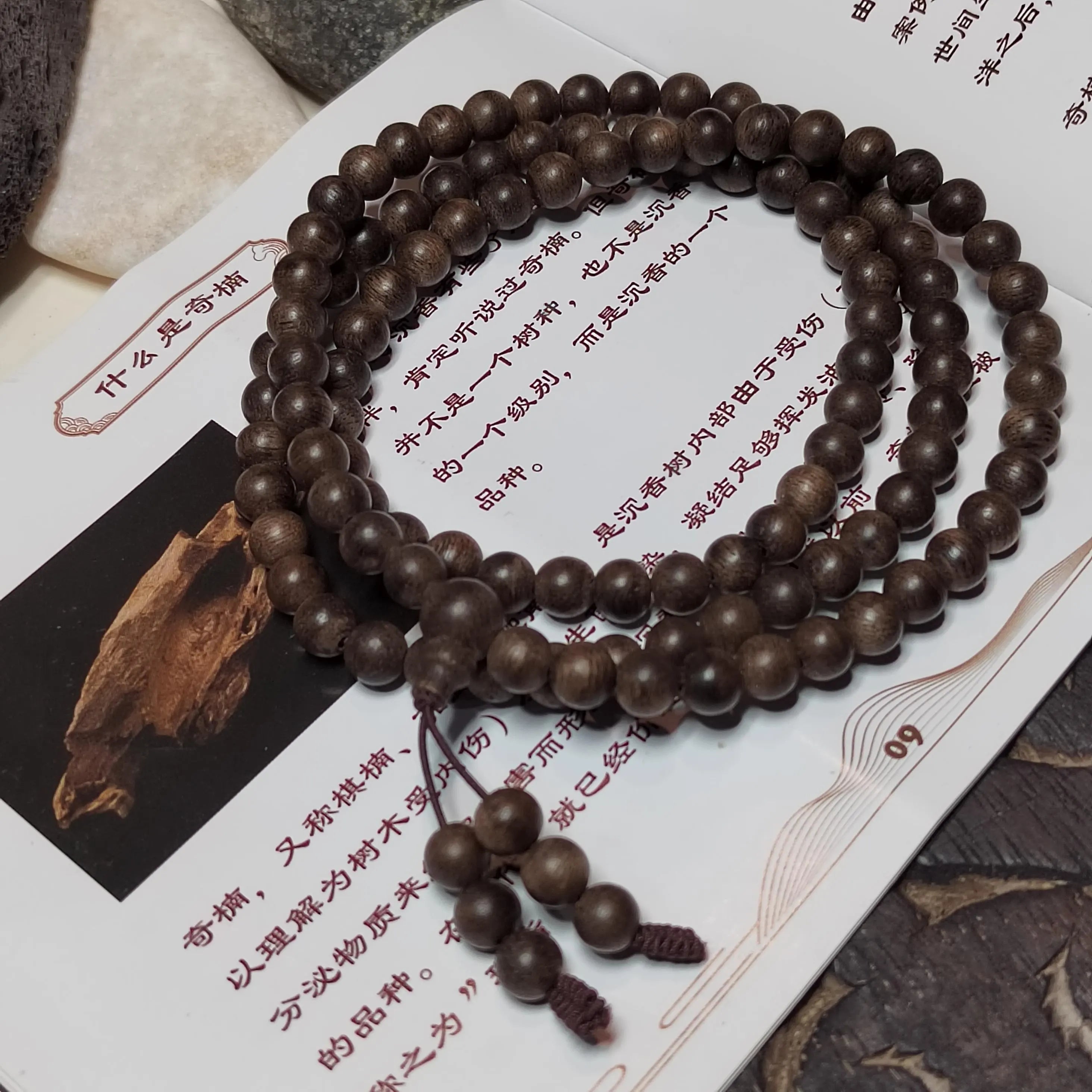 Wooden beaded bracelet on a piece of paper with text and a small wooden object.