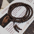 Wooden beaded bracelet on a piece of paper with text and a small wooden object.