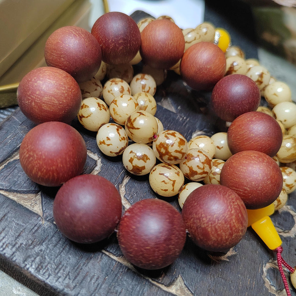 Close-up of a rosary with brown and beige beads on a wooden surface.