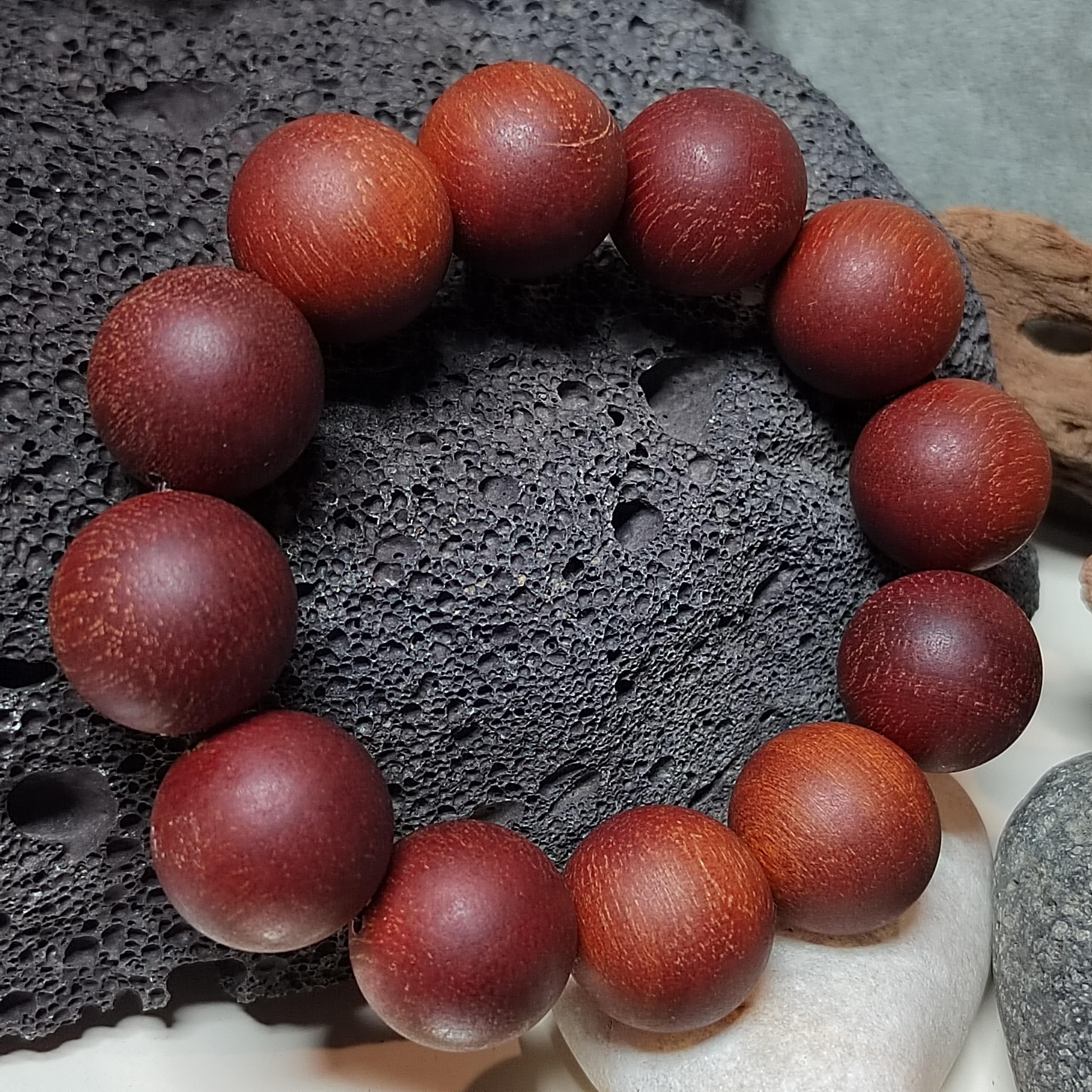 Wooden beaded bracelet on a textured stone surface