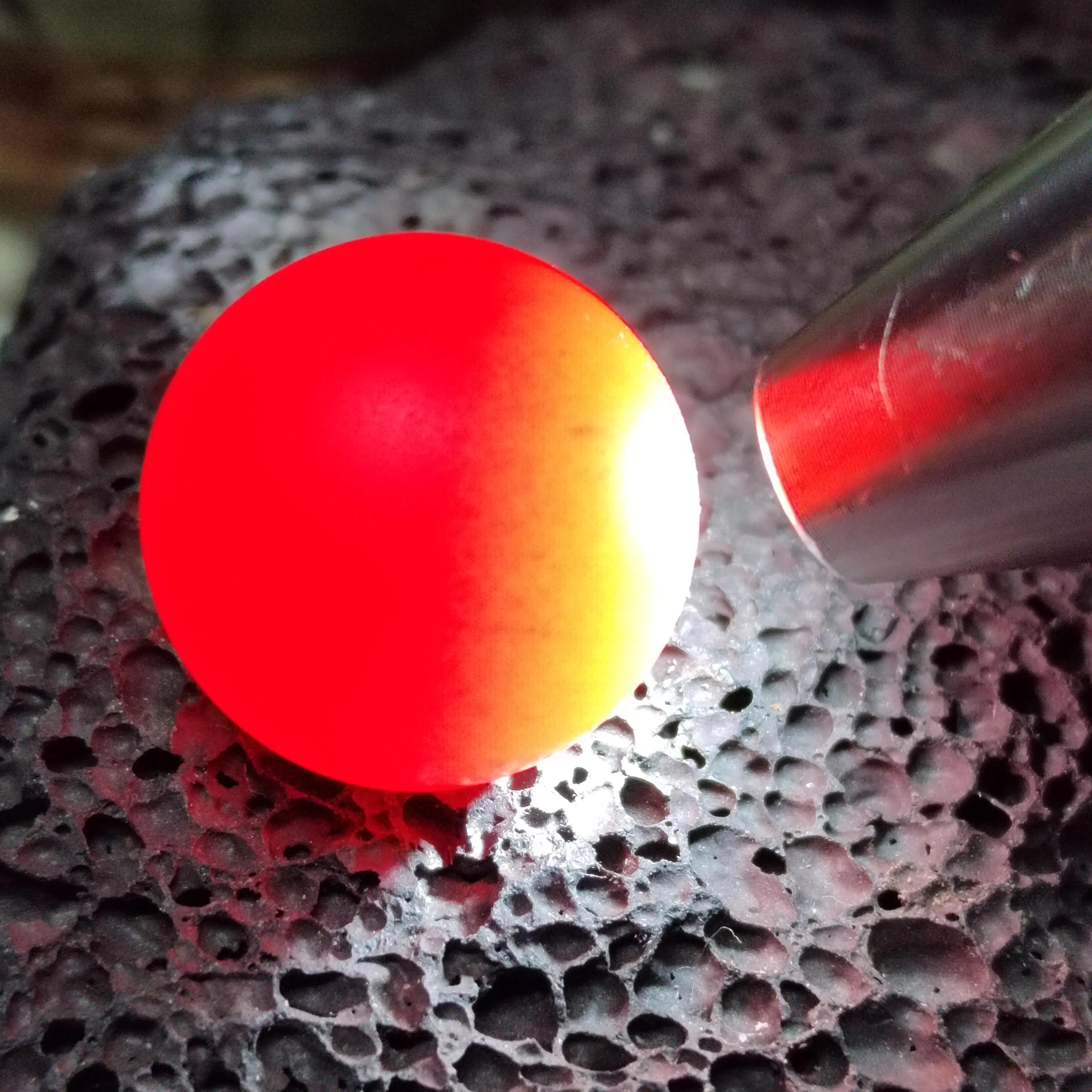 Red Nanhong bead on a textured surface