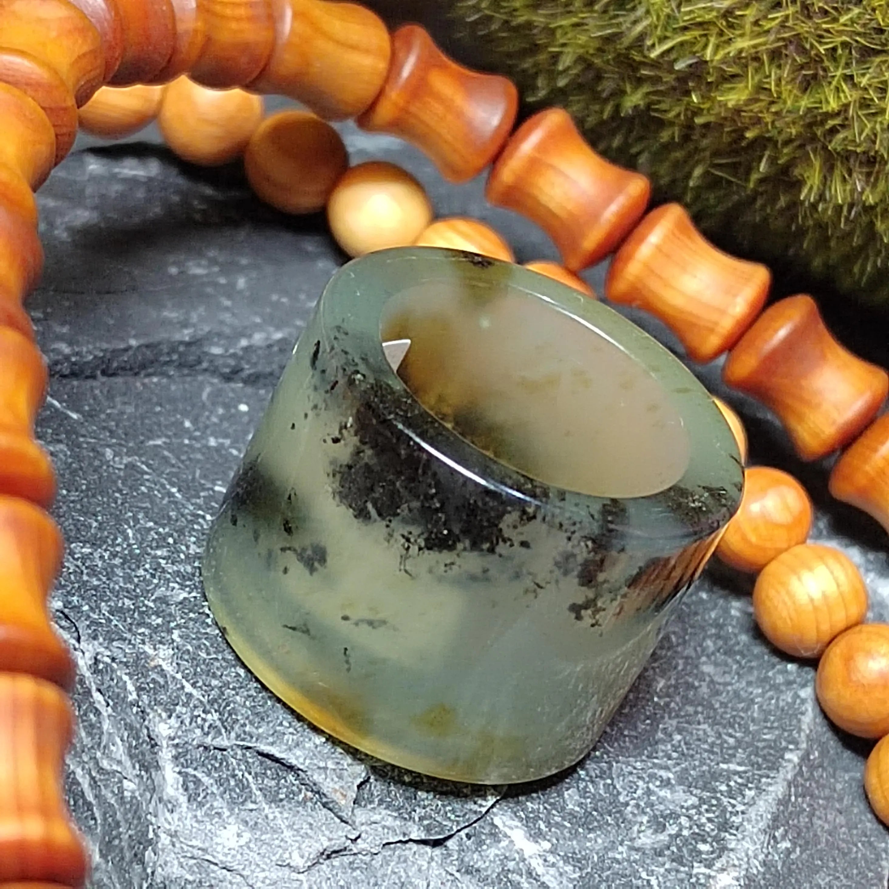 Clear stone with a wooden beaded bracelet on a dark surface