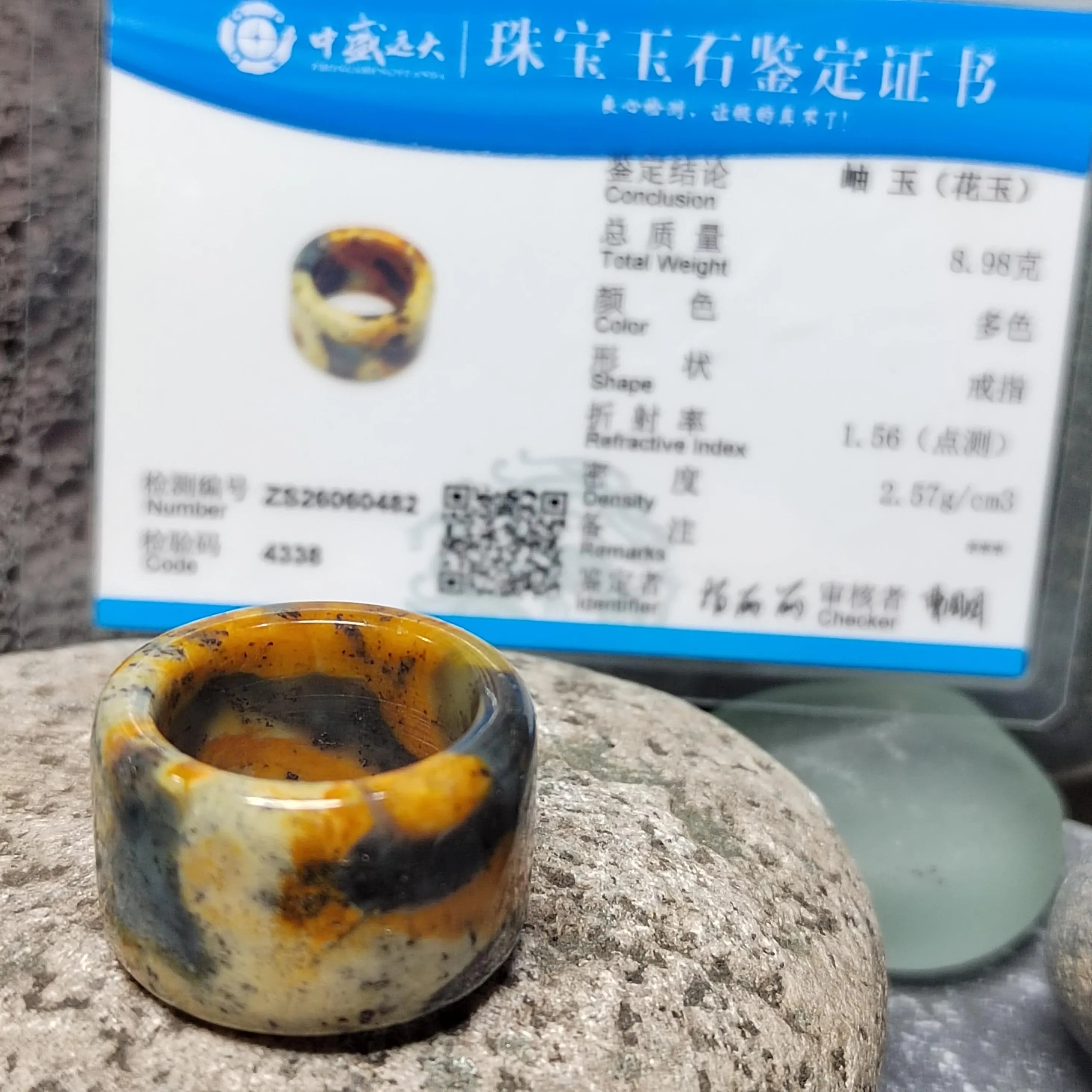 Marbled stone ring on a rock with a certification label in the background