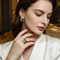 Woman wearing gold earrings and ring, close-up of jewelry